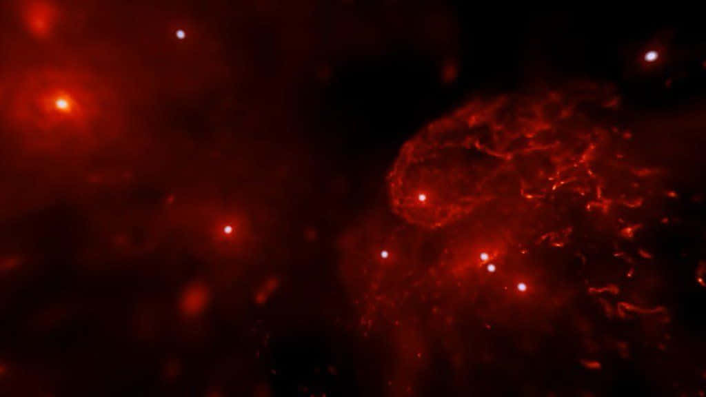 Galactic Center 桌布 壁紙 — 一個宇宙星雲在黑暗虛空中散發出深紅色調和散落的明亮星星。