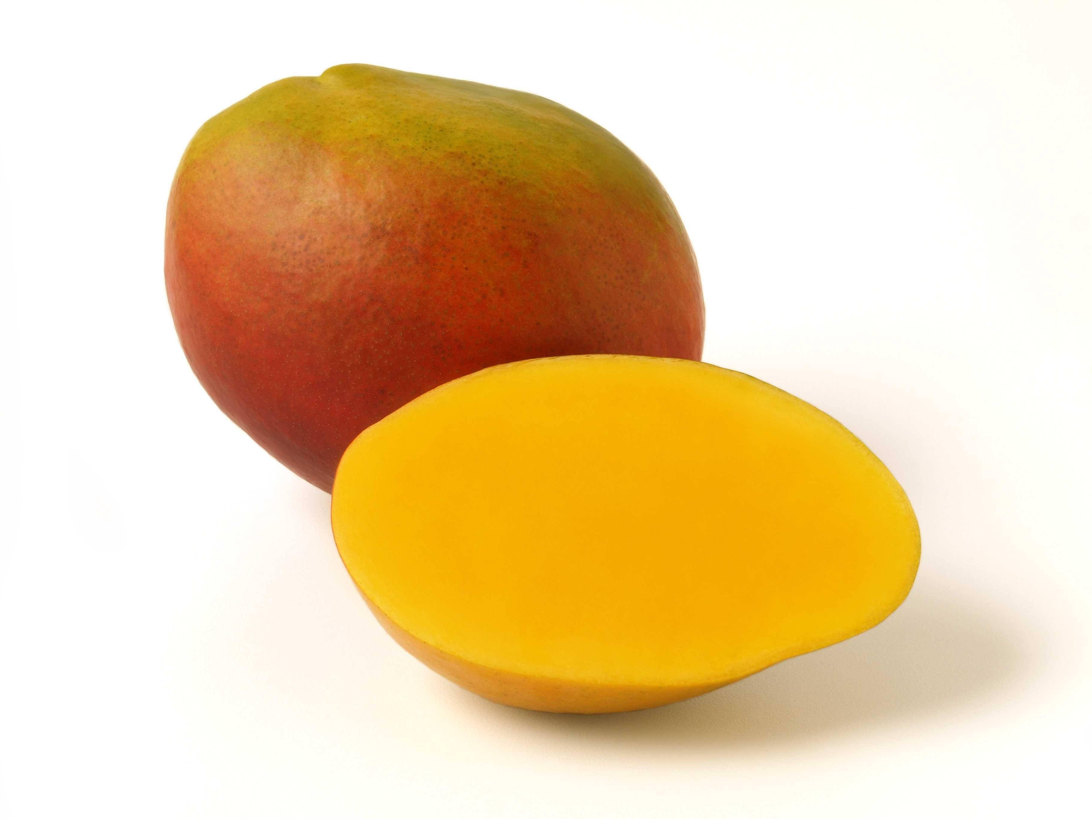 Fruit 桌布 壁紙 — 一個完整成熟的芒果，切開一半露出鮮黃色的果肉，背景是潔淨的白色。