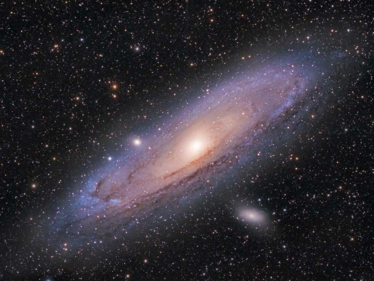 Spiral Galaxy 桌布 壁紙 — 一個宏偉的螺旋星系在星空中散發出溫暖的橙色和冷藍色調。