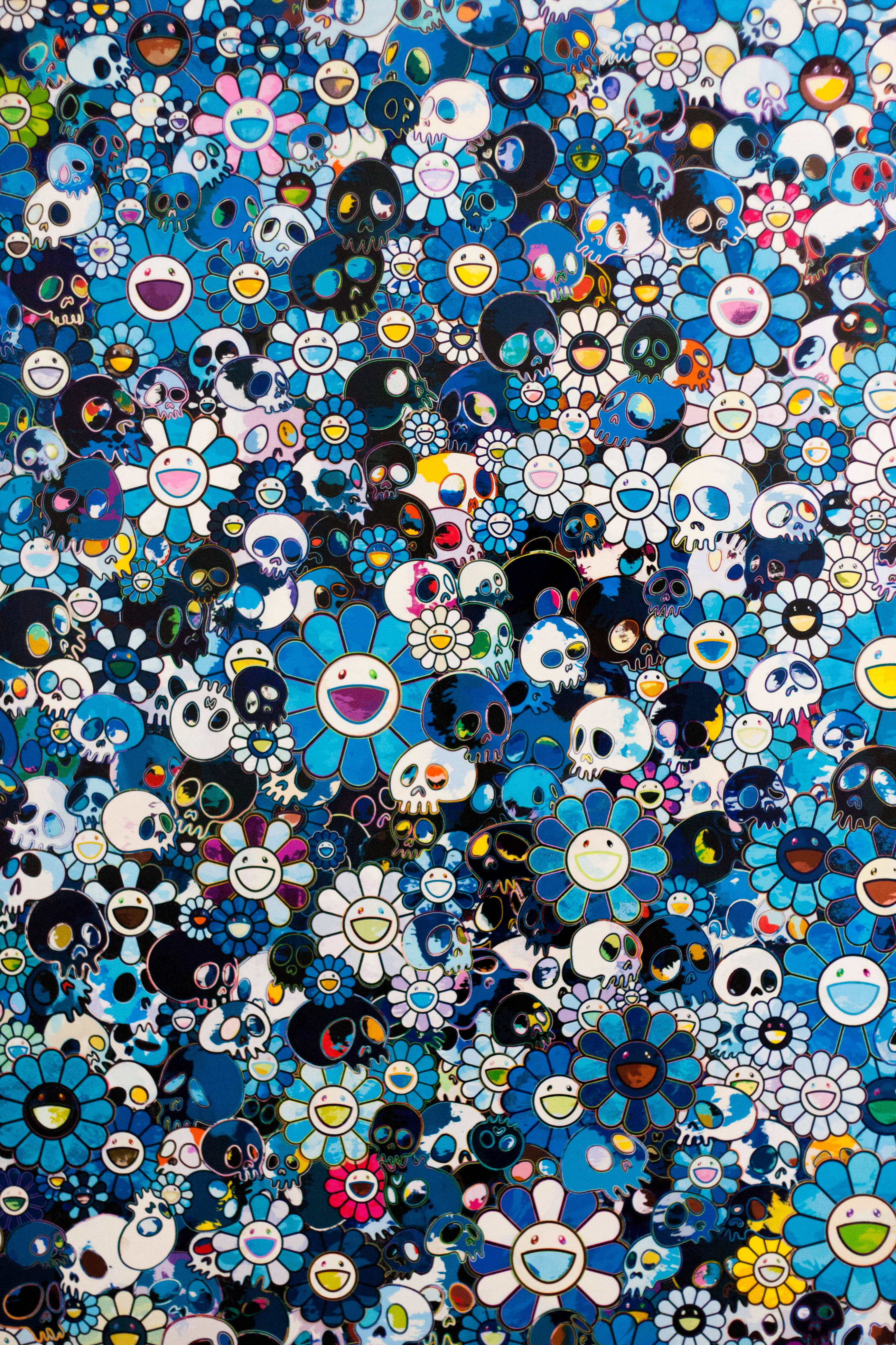 Only Blue Takashi Murakami 4K 壁紙 — 一個密集而充滿活力的圖案，由藍色雛菊和帶笑臉的骷髏頭組成，呈現出混亂多彩的拼貼效果。
