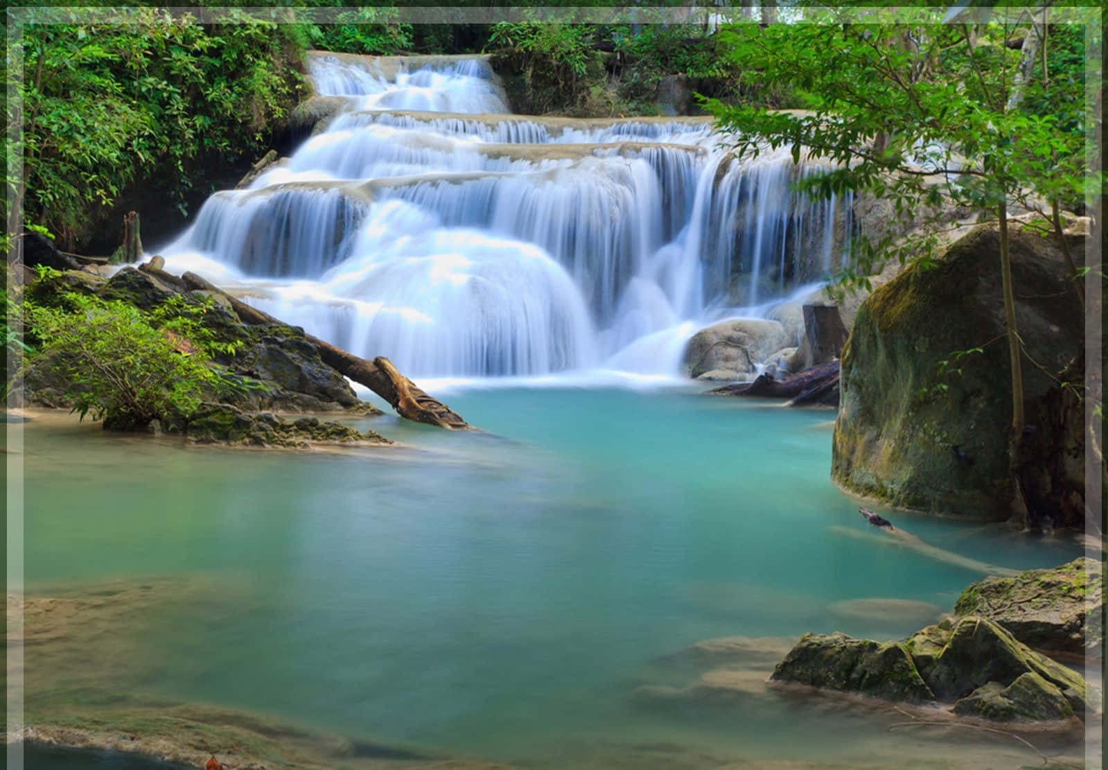 3d Waterfall 桌布 壁紙 — 一個寧靜的多層瀑布傾瀉而下，流入一個被茂密綠色叢林樹葉環繞的碧綠水池。