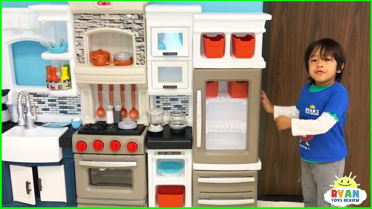 toys 桌布 壁紙 — 一個小孩企喺一個色彩繽紛嘅玩具廚房套裝旁邊，套裝有逼真嘅電器同配件。
