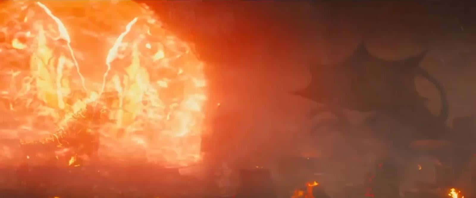Burning Godzilla 桌布 壁紙 — 一個巨大的火焰怪物從熾熱的橙色和紅色地獄中爆發，映襯著煙霧瀰漫的黑暗天空。