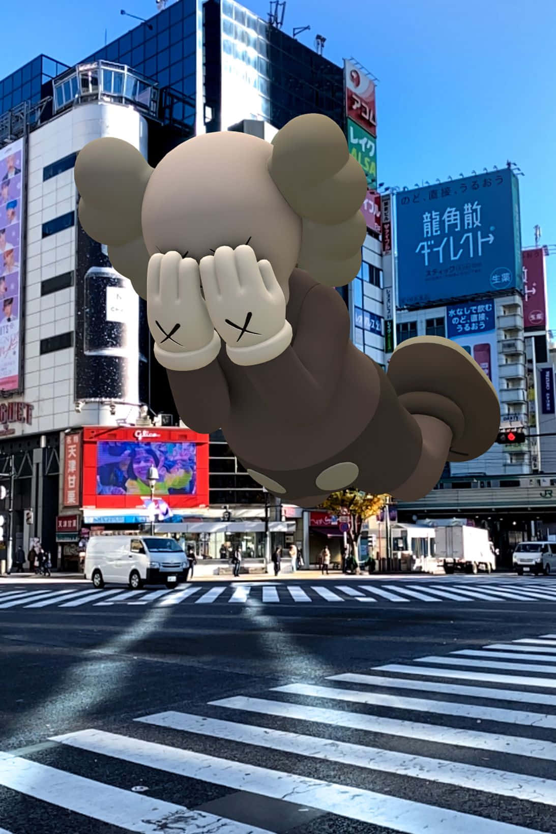 Kaws Holiday 桌布 壁紙 — 一個巨大的米色KAWS熊氣球漂浮在繁忙的東京十字路口上空，天空清澈湛藍。