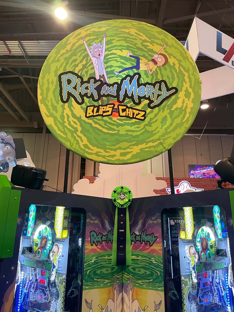 Blips And Chitz 桌布 壁紙 — 一個巨大的綠色傳送門標誌，上面有瑞克和莫蒂的角色，懸掛在會議上的兩台街機上方。