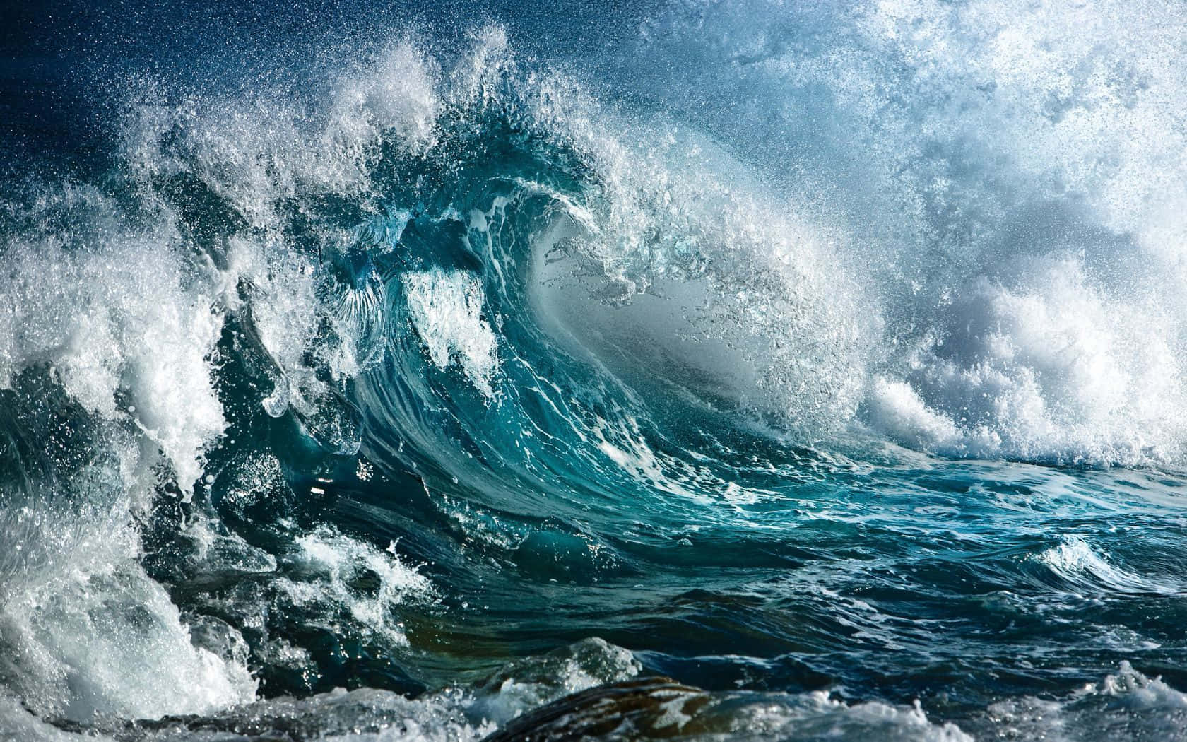 海浪 桌布 壁紙 — 一個巨大的藍綠色海浪強力地捲曲在頭頂，帶著泡沫般的白色浪花，映襯著深藍色的海洋。