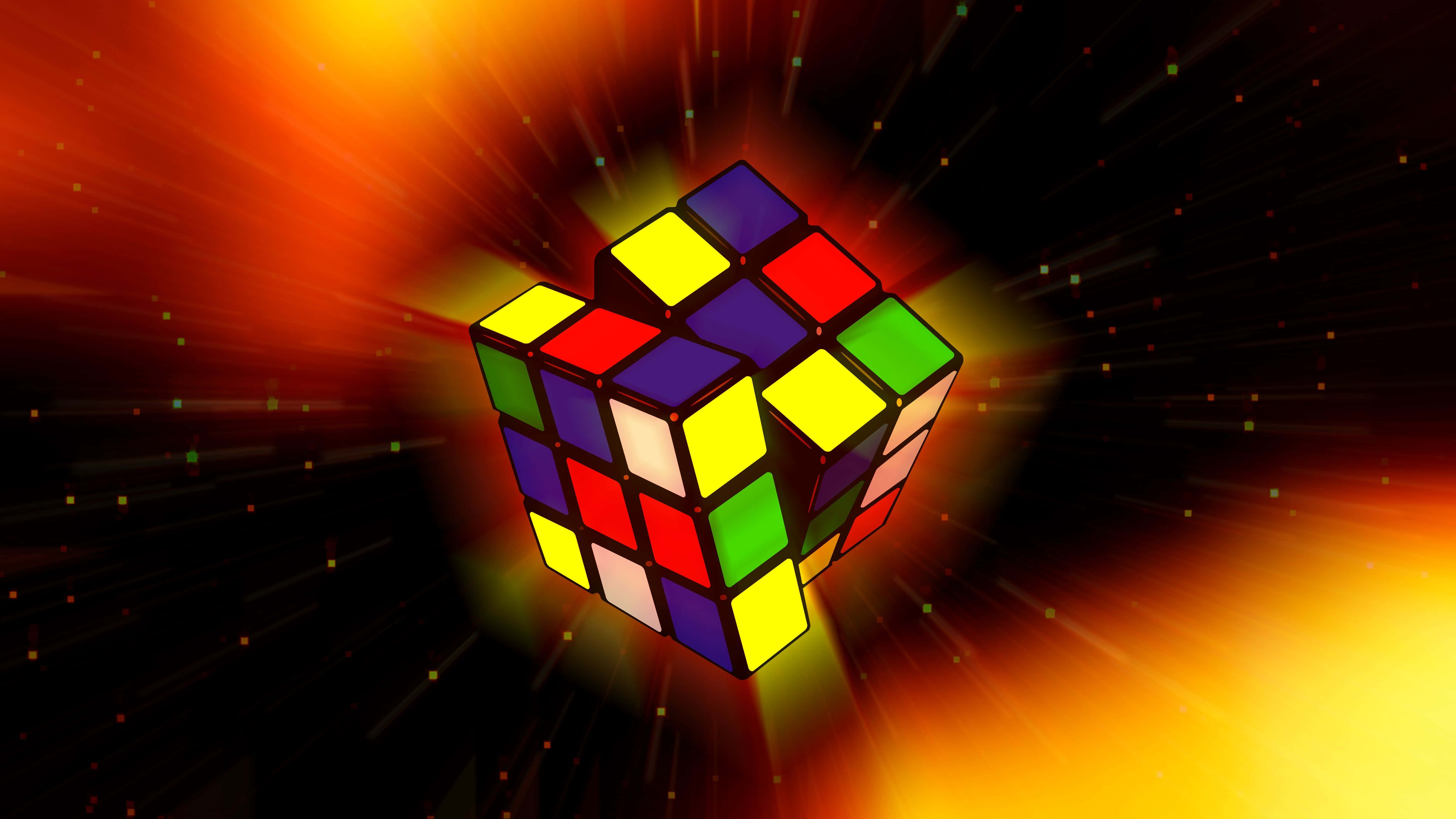 Concentration 桌布 壁紙 — 一個已解開的扭計骰在帶有星芒射線的耀眼橙色和黃色宇宙背景中發光。