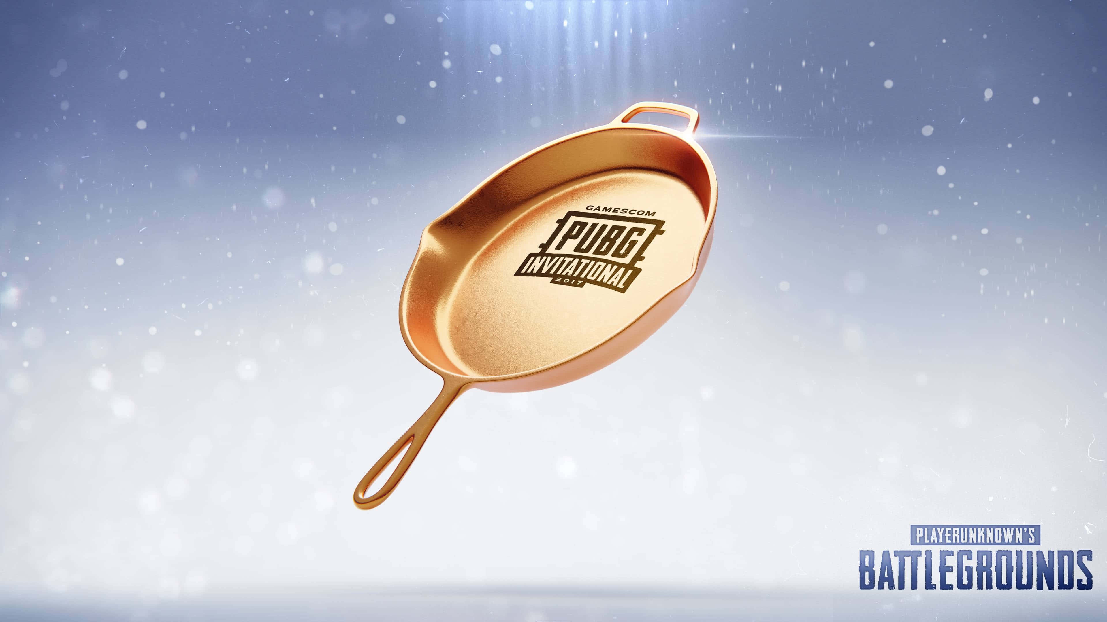 Pubg Logo 桌布 壁紙 — 一個帶有PUBG標誌的金色煎鍋漂浮在雪天中，伴隨著光線和散景粒子。