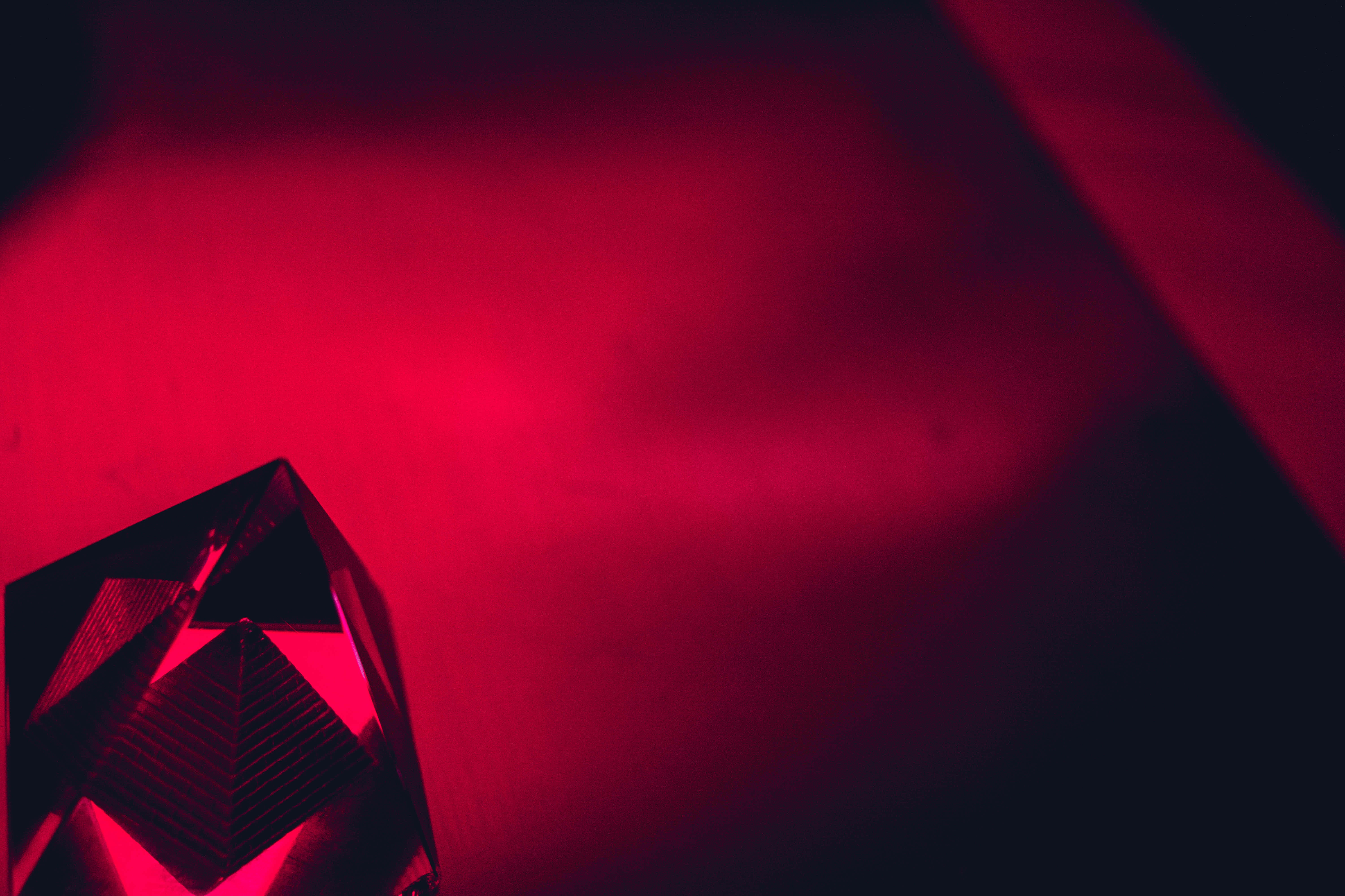 Red Diamond 桌布 壁紙 — 一個帶有切面的幾何水晶在深色漸變背景上折射出強烈的紅光。