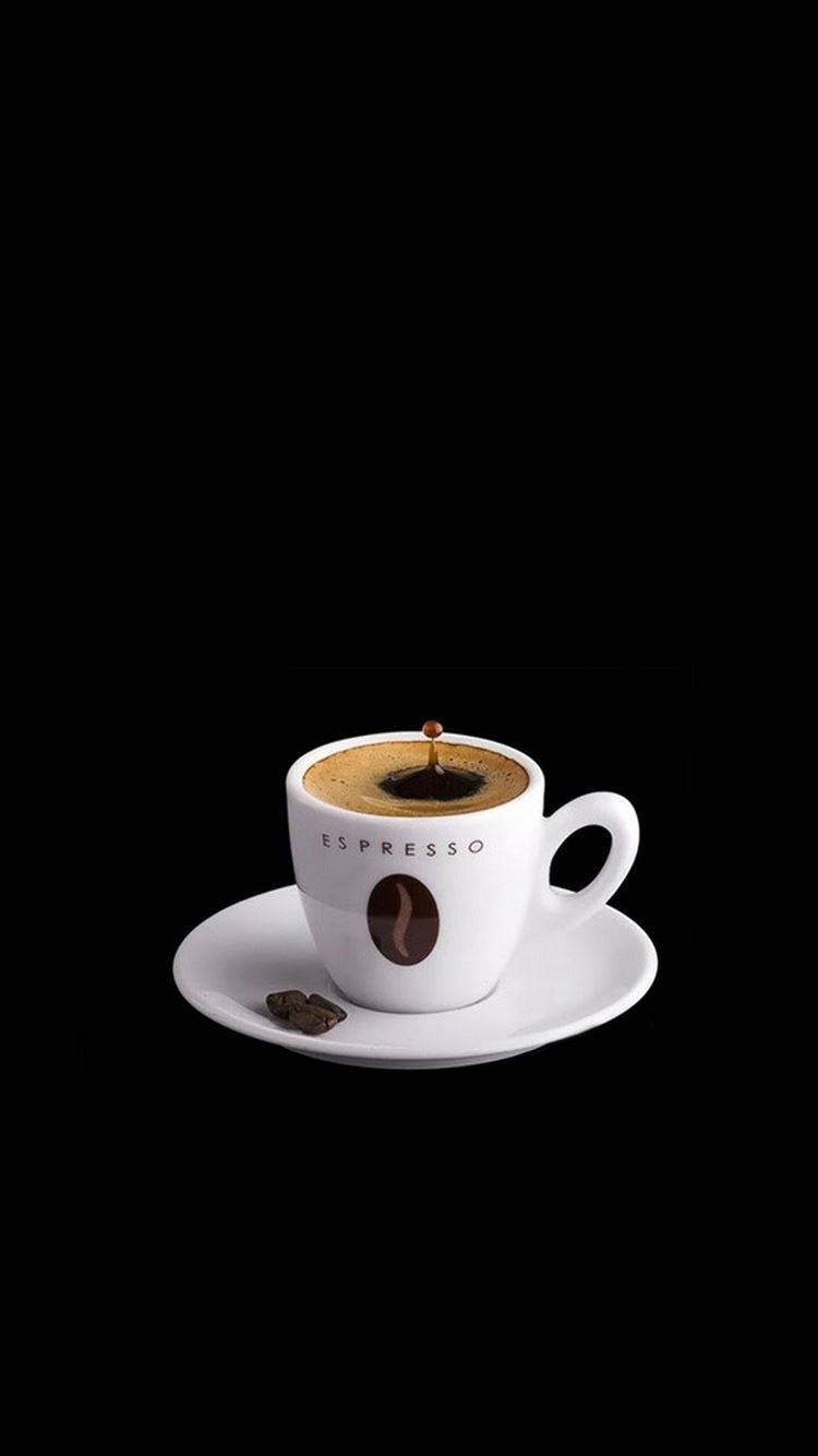 Coffee Aesthetic 桌布 壁紙 — 一個帶有咖啡豆標誌的白色濃縮咖啡杯放在碟子上，背景為黑色，單滴咖啡懸浮在油脂上方。
