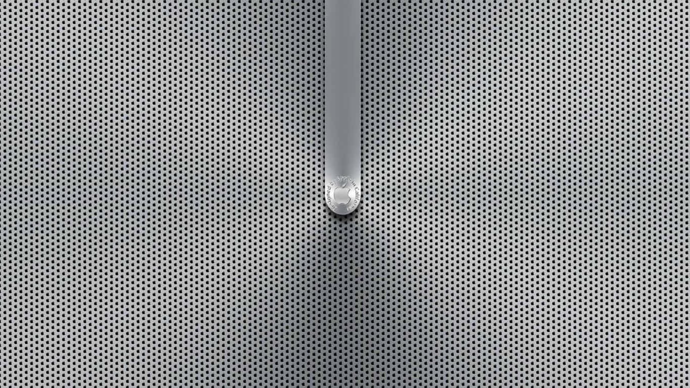 metal 桌布 壁紙 — 一個帶有圓形標誌的時尚銀色手柄垂直穿過均勻穿孔的金屬格柵。