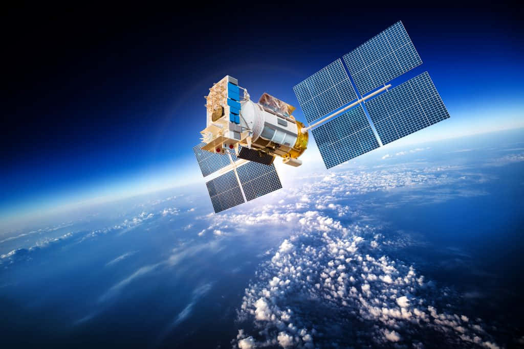Satellite Technology 桌布 壁紙 — 一個帶有太陽能板的詳細衛星在地球的藍色大氣層和白色雲層上方運行。
