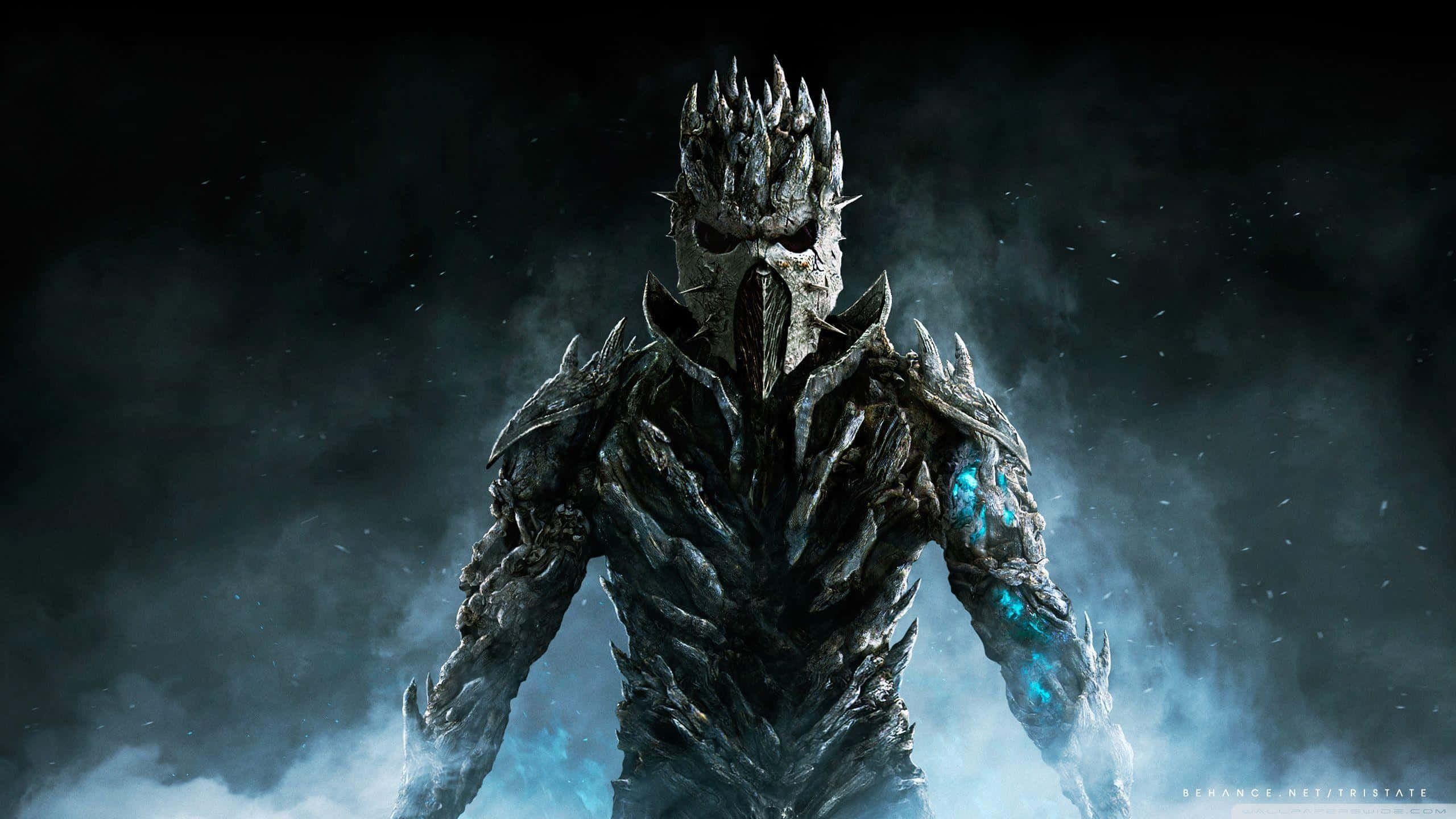 Skyrim Dawnguard 桌布 壁紙 — 一個帶有尖刺頭盔和發光藍色血管的威脅性裝甲人物從黑暗迷霧中出現，在暴風雨的天空下。