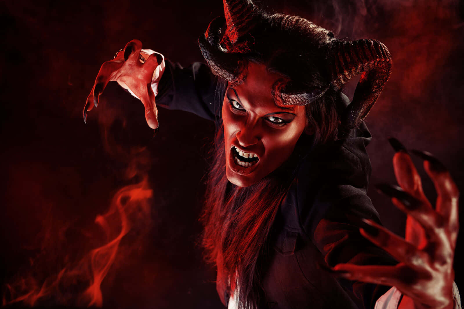 Witching Hour 桌布 壁紙 — 一個帶有發光眼睛和角的威脅性惡魔在火紅的迷霧中向前猛撲。