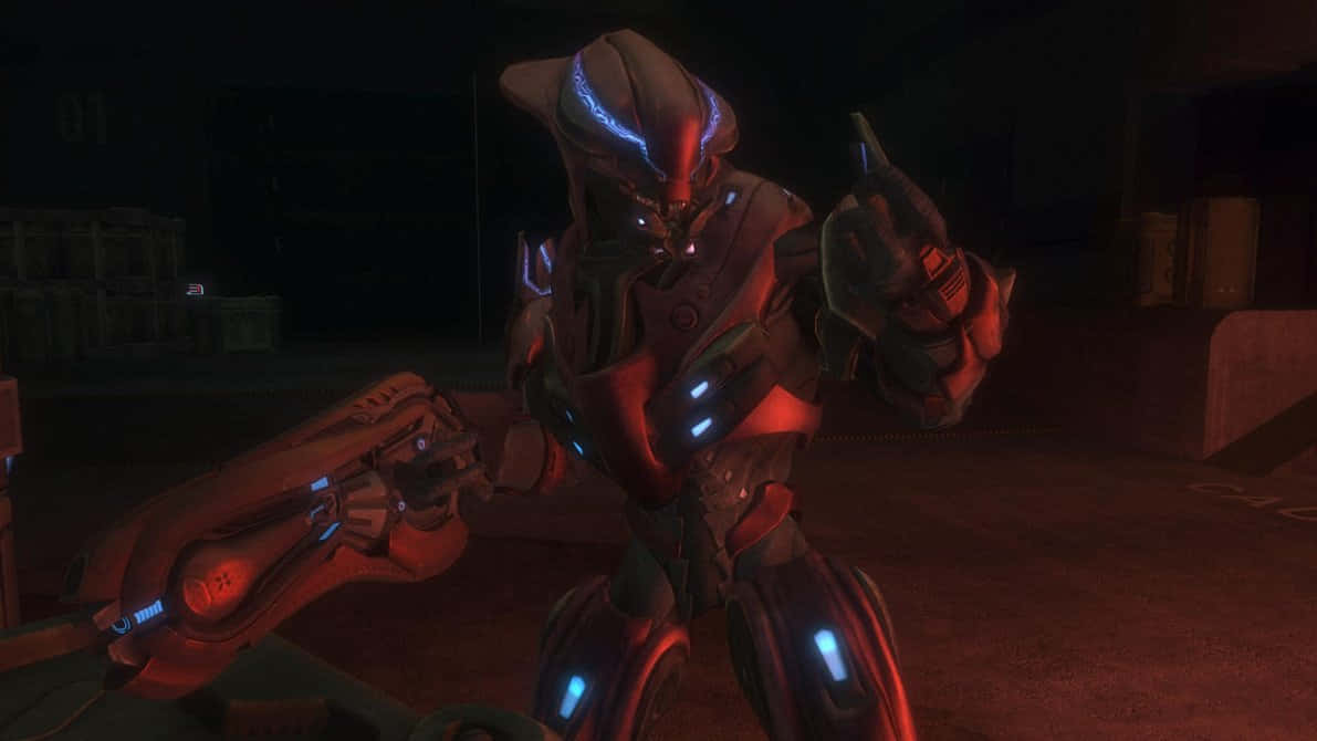 Halo Covenant 桌布 壁紙 — 一個帶有發光藍色裝甲的威脅性外星戰士，站在光線昏暗的工業環境中，手持未來武器。