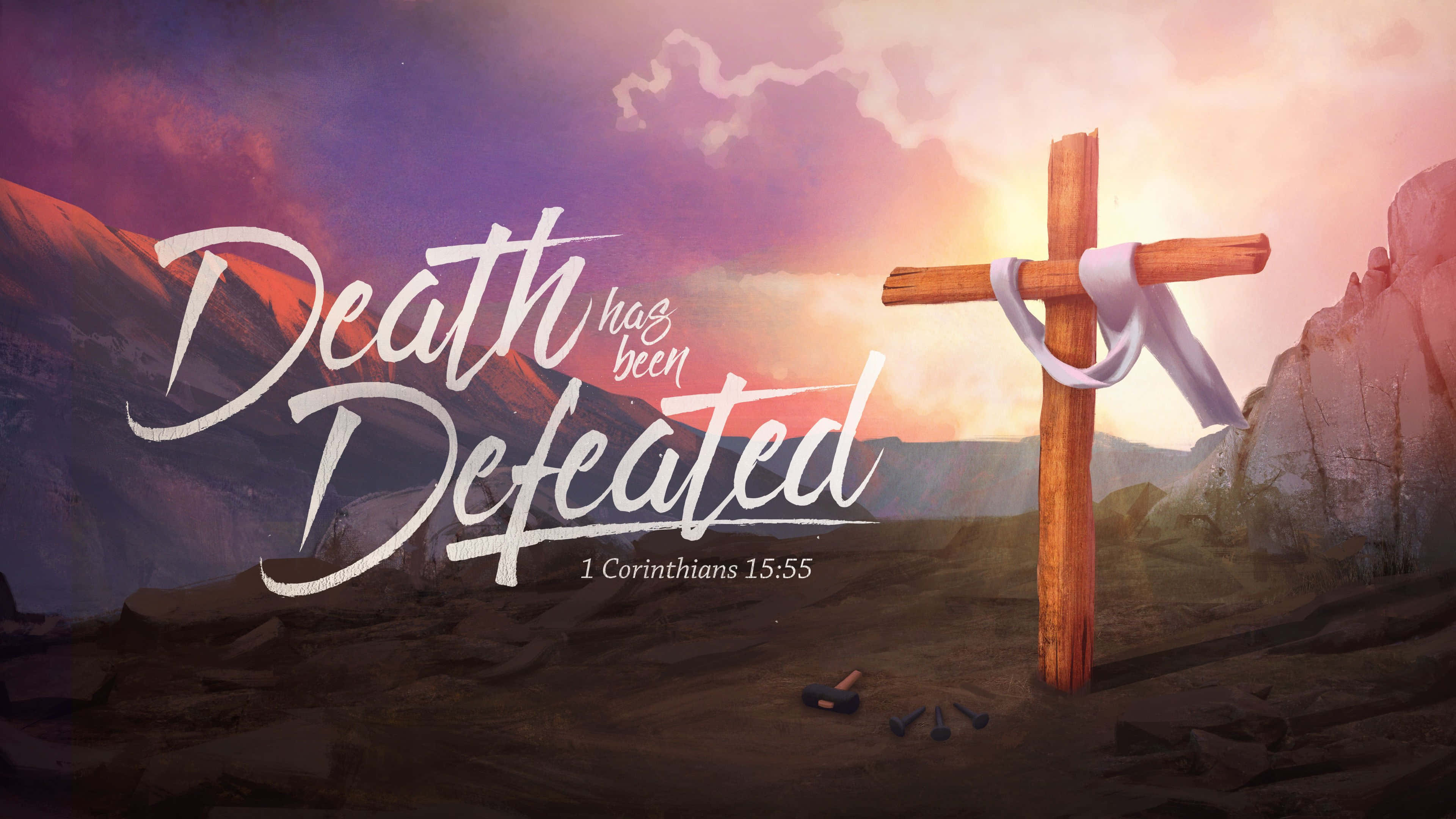 Jesus Crucifixion 桌布 壁紙 — 一個帶有白色絲帶的木製十字架矗立在日落時分的岩石沙漠中，上面覆蓋著「死亡已被擊敗」和「哥林多前書 15:55」的文字。