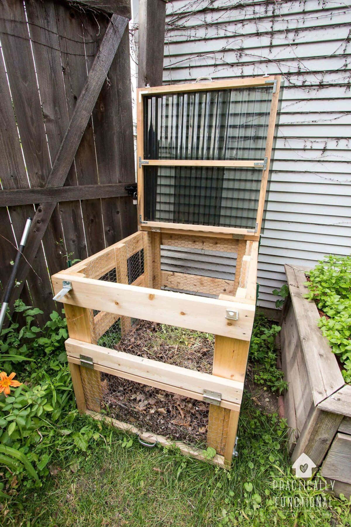 Compost 桌布 壁紙 — 一個帶有篩網蓋的木製堆肥箱放在有圍欄和花園床的草地後院。