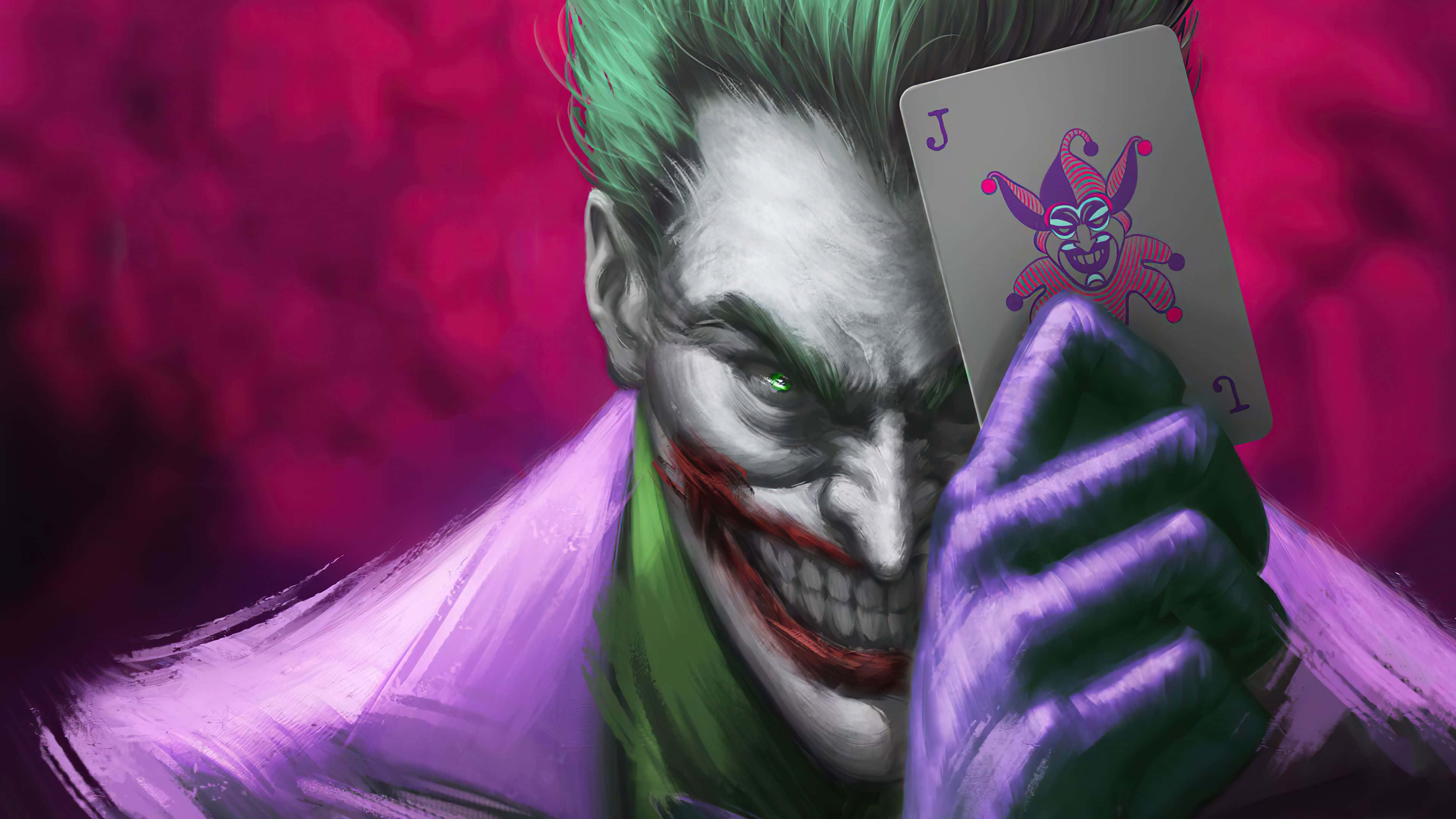 Joker Card 桌布 壁紙 — 一個帶有綠色頭髮和紫色手套的威脅性小丑，在充滿活力的洋紅色背景前拿著一張小丑牌。