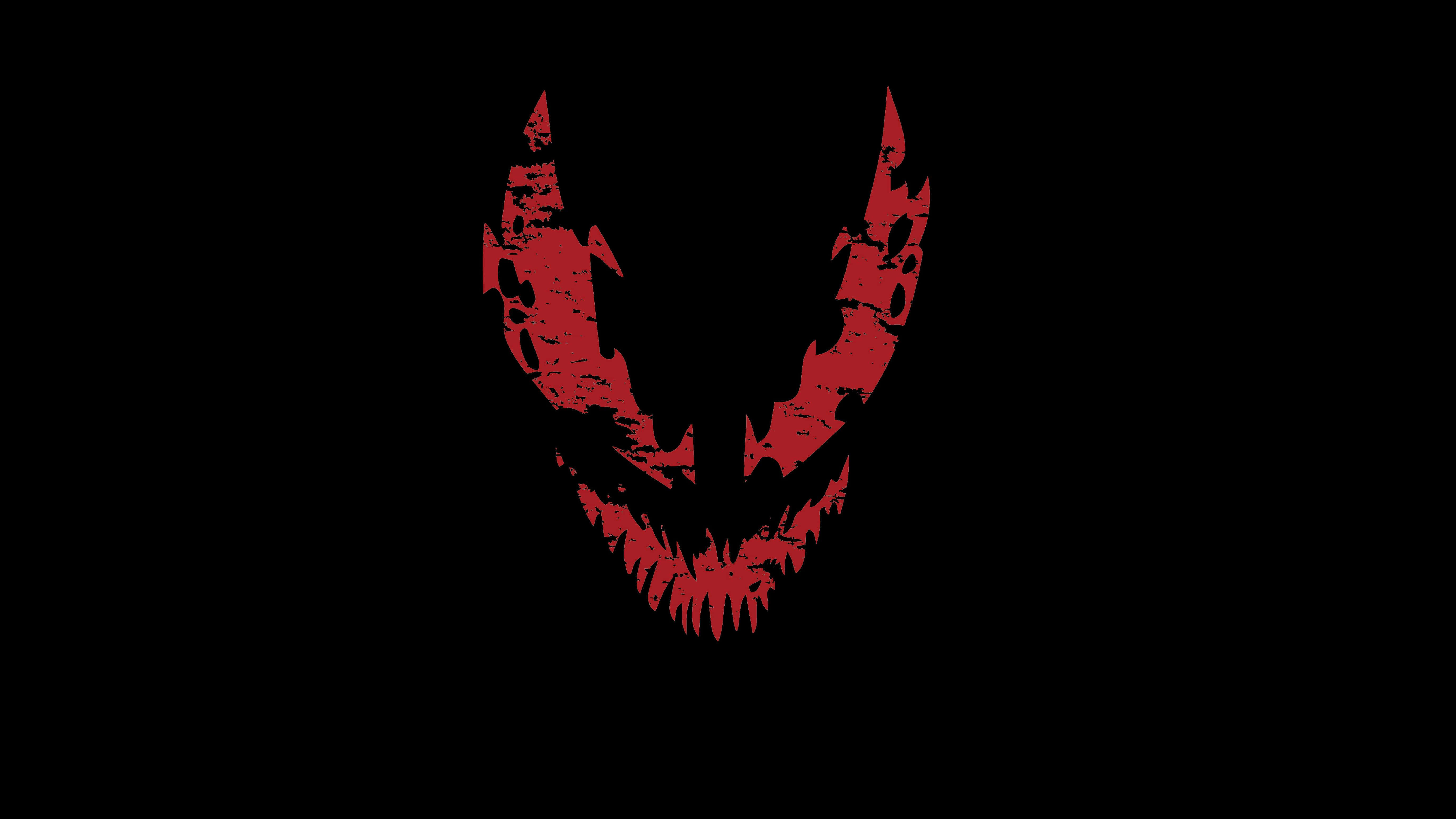 Carnage USA 桌布 壁紙 — 一個帶有鋸齒狀牙齒和角的紅色可怕骷髏頭在純黑色背景上發光。
