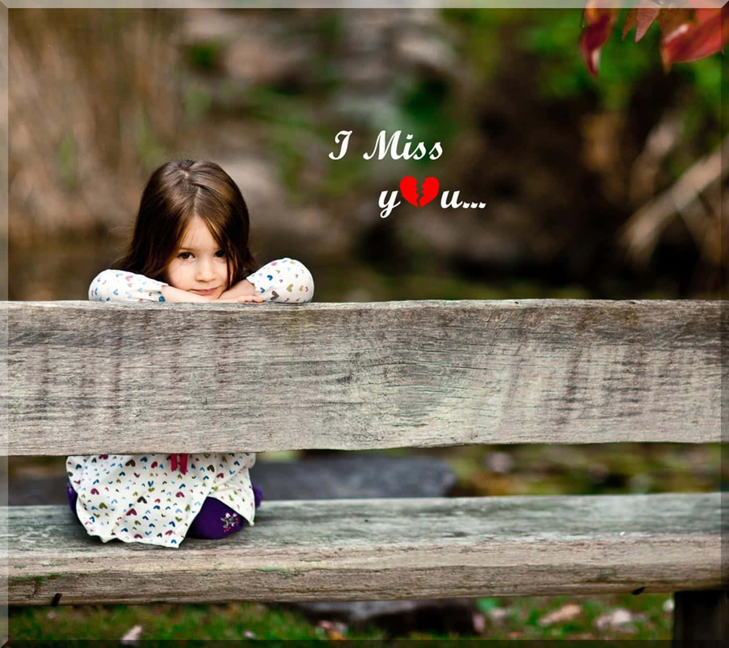 I Miss You 桌布 壁紙 — 一個年輕女孩將下巴擱在風化的木長椅上，背景是柔焦的自然環境，帶有文字疊加顯示「I Miss you...」和一個破碎的心。