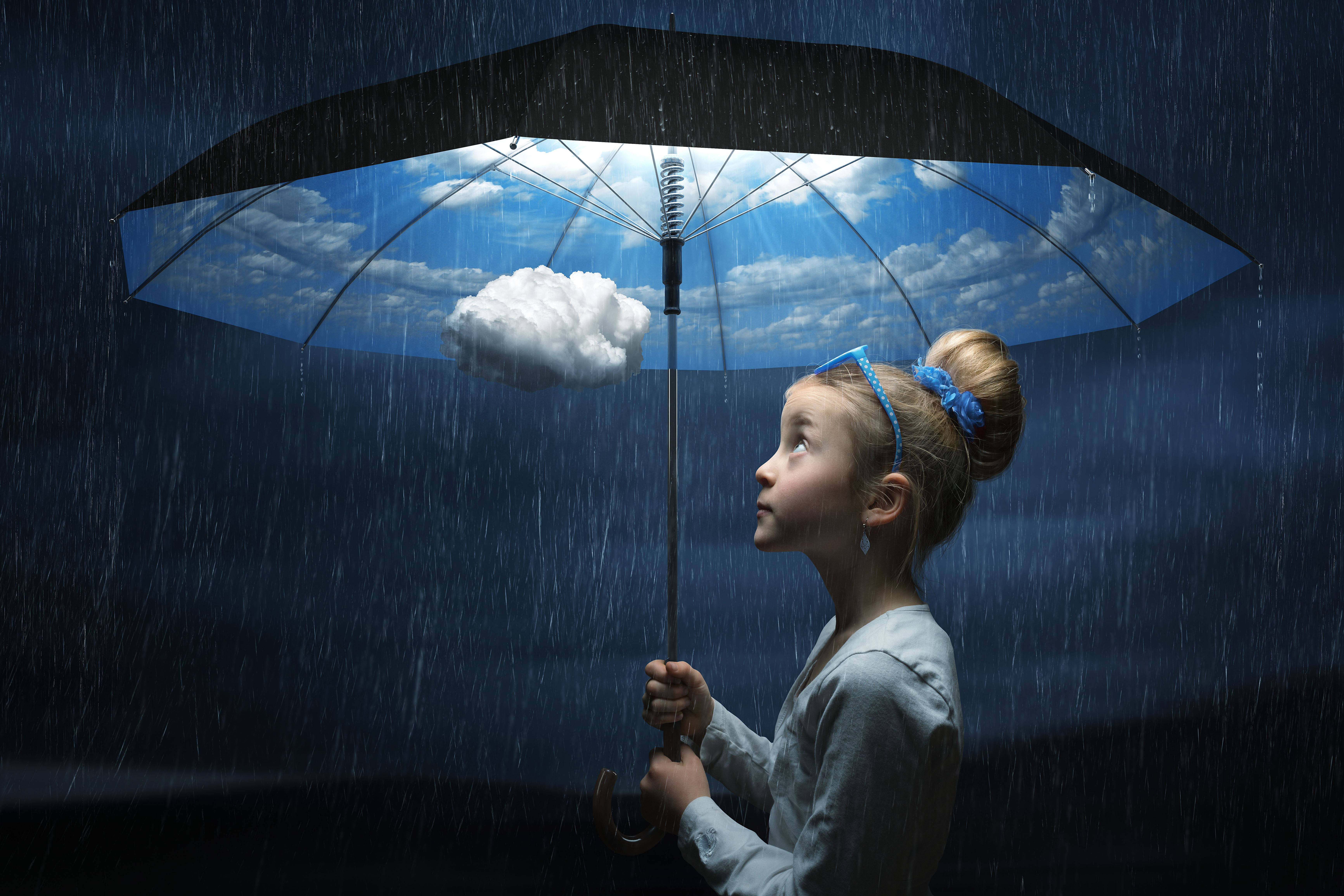 Creative 桌布 壁紙 — 一個年輕女孩拿著一把黑色雨傘，露出明亮的藍天和蓬鬆的雲朵，周圍下著雨，環境陰暗。