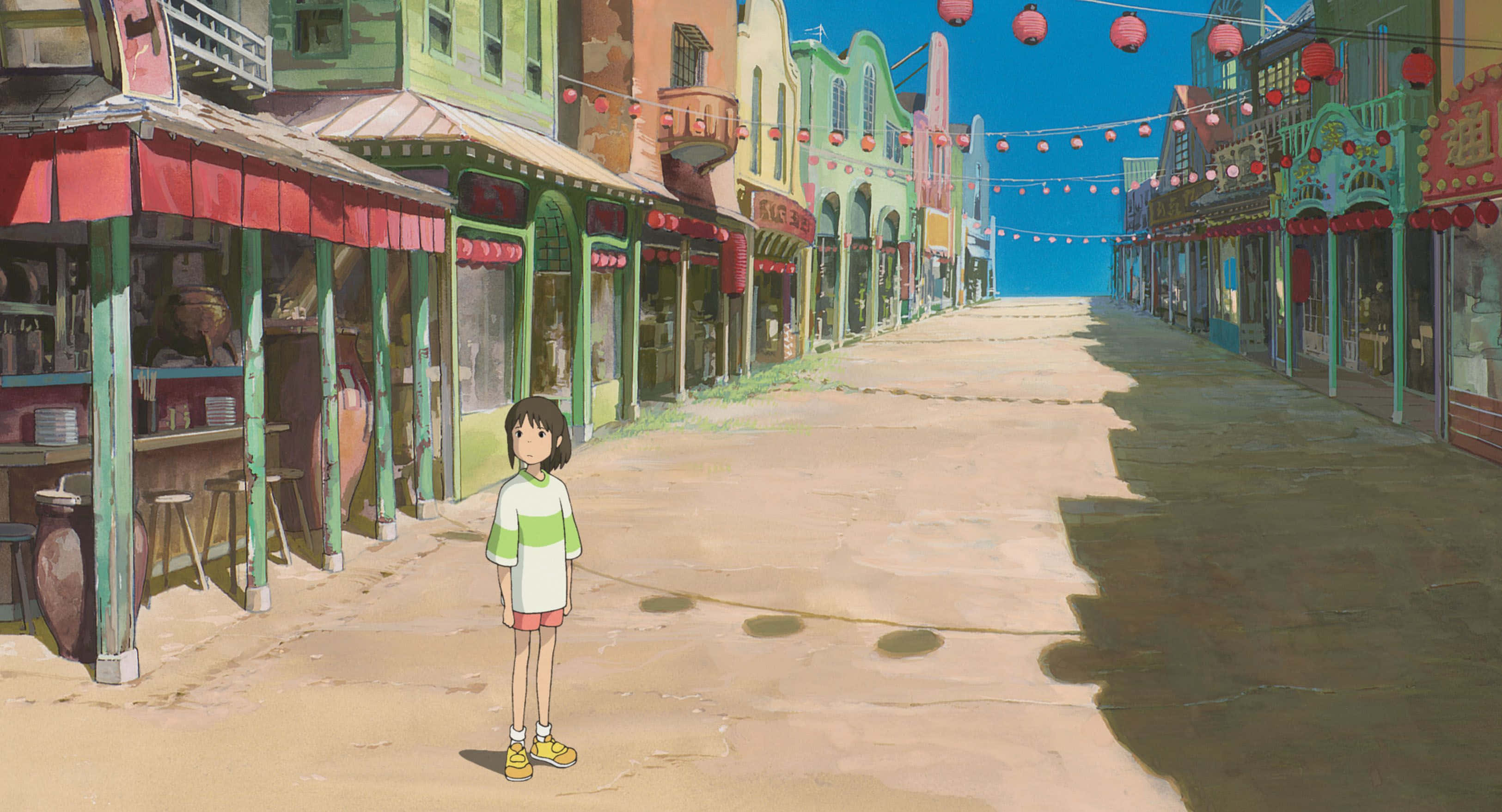 Hayao Miyazaki Movies 桌布 壁紙 — 一個年輕女孩獨自站在一條陽光普照、空無一人的街道上，兩旁是色彩繽紛的建築物和紅色燈籠，頭頂是清澈的藍天。