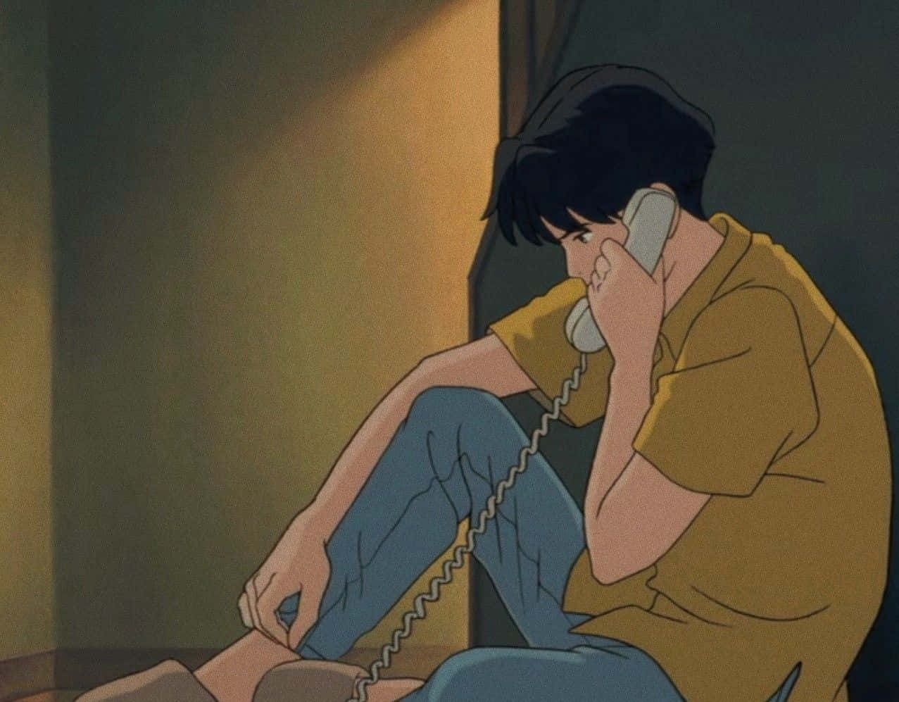 Studio Ghibli Ocean Waves 桌布 壁紙 — 一個年輕男子癱坐在牆邊，將電話貼在耳邊，身處燈光昏暗的房間，溫暖的光線投下陰影。
