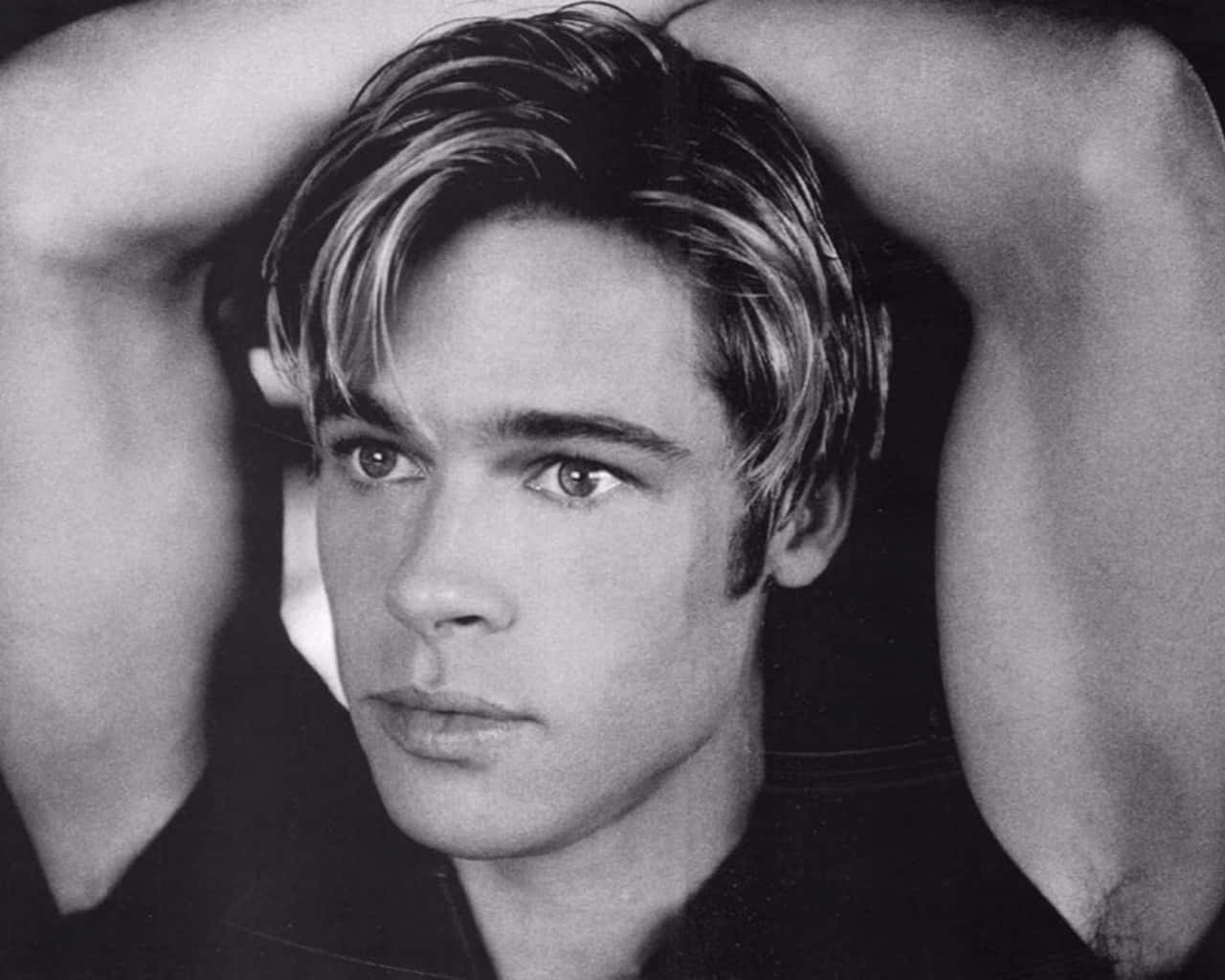 Brad Pitt 桌布 壁紙 — 一個年輕男子的黑白肖像，雙手放在腦後，直視鏡頭。