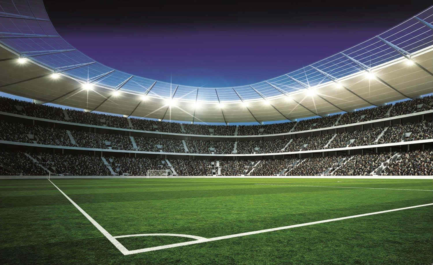 3d Sports 桌布 壁紙 — 一個廣闊的夜間照明足球場，紫色天空下擠滿歡呼的球迷。
