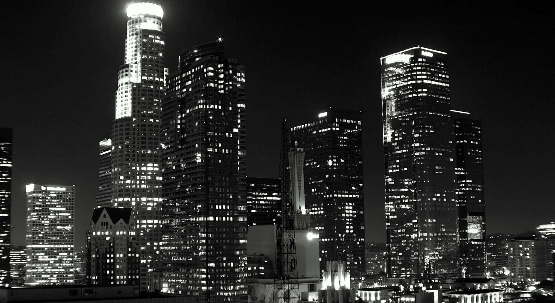 Black And White Cityscape 桌布 壁紙 — 一個引人注目的黑白夜景，呈現密集的城市天際線，高聳的摩天大樓閃爍著明亮的窗戶。