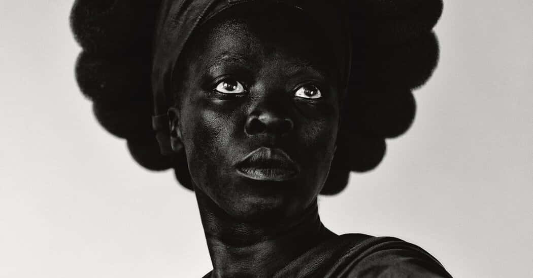 Black Culture 桌布 壁紙 — 一個引人注目的黑白肖像，一位女性擁有豐滿的非洲式髮型，在純色背景下向上凝視，眼神強烈。