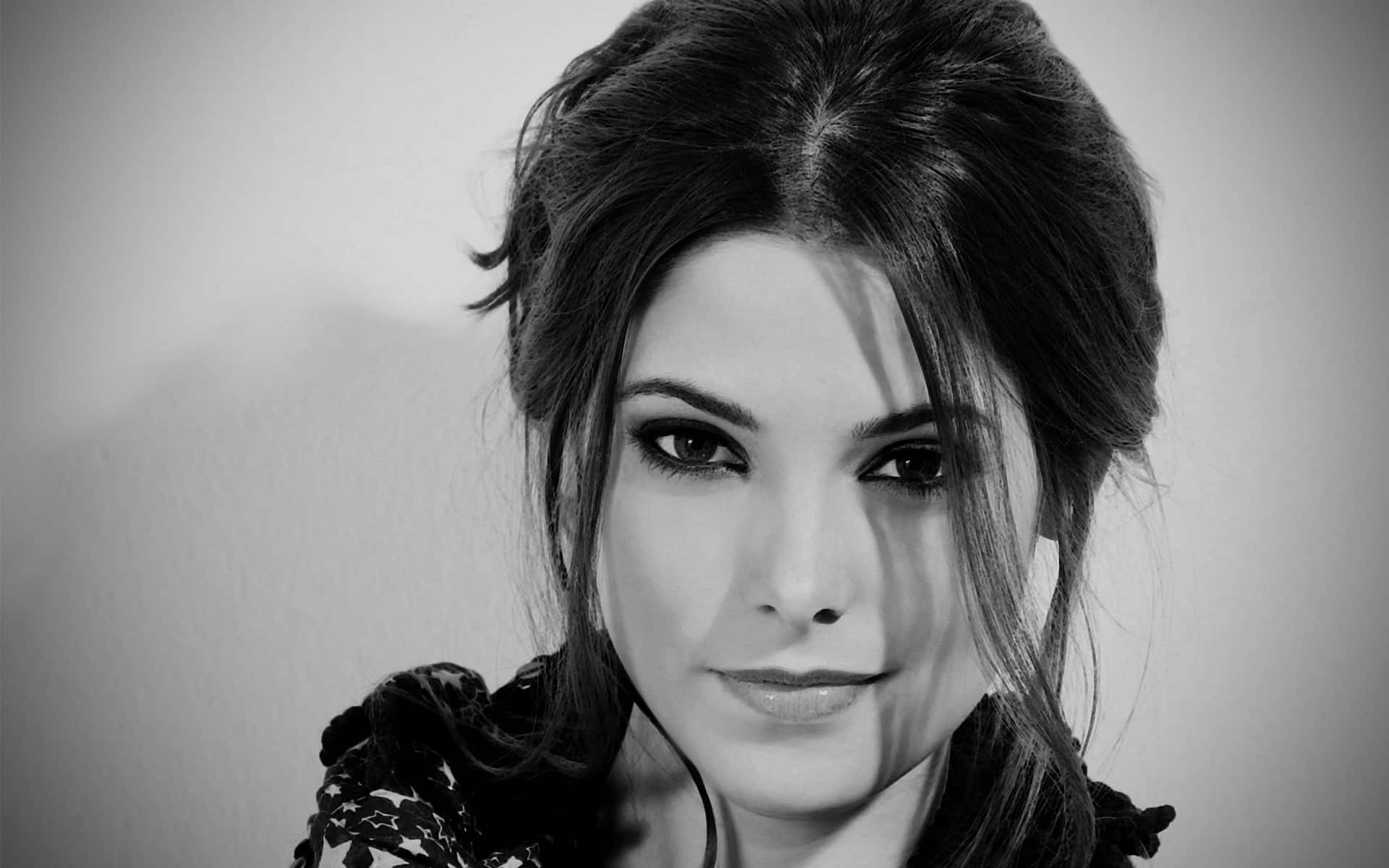 ashley greene 桌布 壁紙 — 一個引人注目的黑白肖像，一位眼神銳利、頭髮造型時尚的女性直視鏡頭。