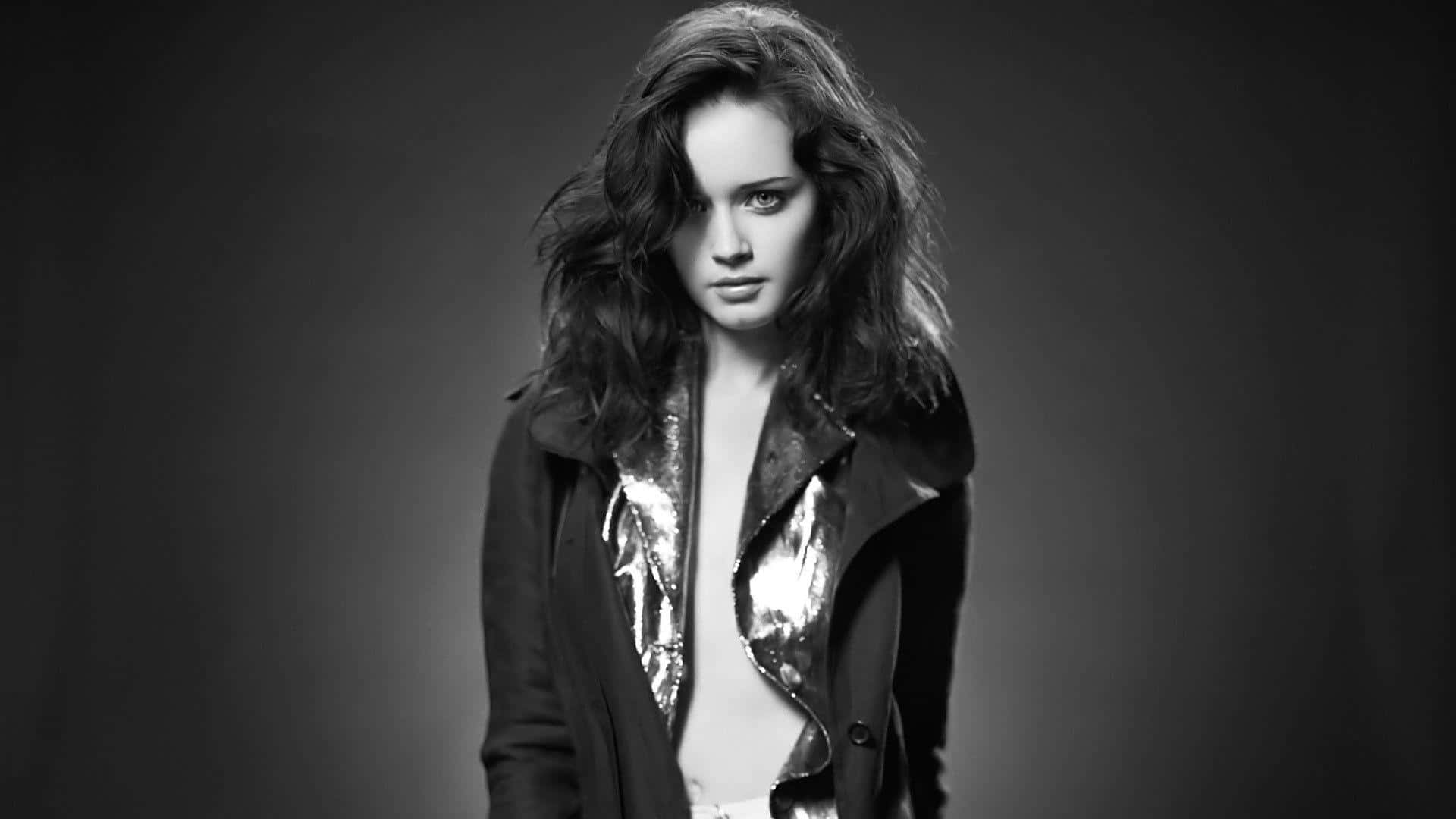 Alexis Bledel 桌布 壁紙 — 一個引人注目的黑白肖像，一位頭髮蓬亂的女性穿著帶有閃亮金屬領的夾克。