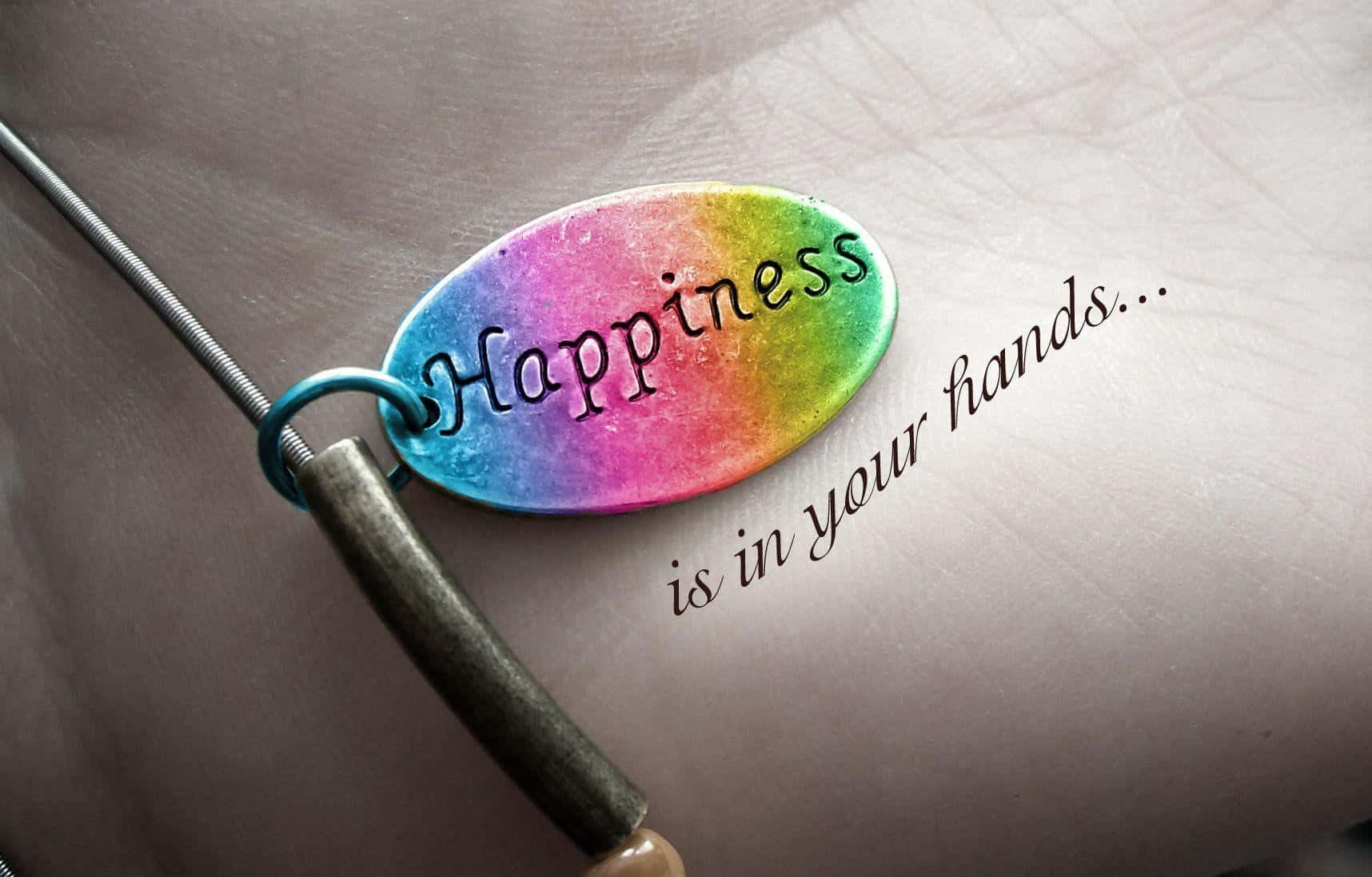 happiness 桌布 壁紙 — 一個彩虹色的飾物上刻有「Happiness」，放在一隻手上，旁邊寫著「is in your hands...」。