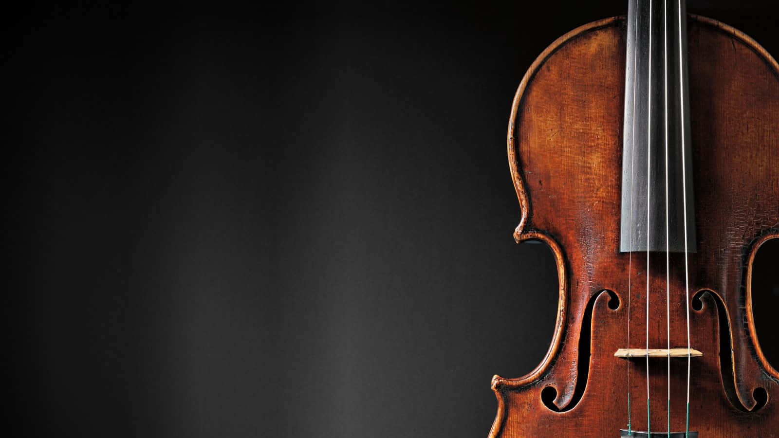 Classical Music 桌布 壁紙 — 一個復古小提琴的特寫，擁有豐富的琥珀色木紋和銀色琴弦，背景為深色漸變。