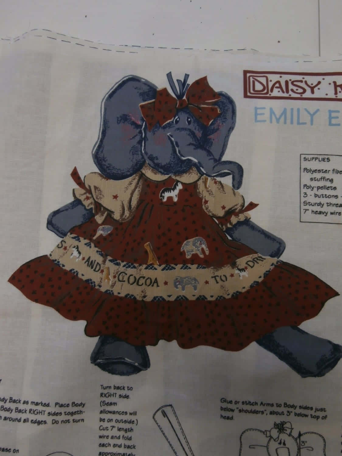 Emily Elephant 桌布 壁紙 — 一個復古縫紉圖案，用於製作一隻穿著紅色圓點連衣裙、帶有大象和星星圖案的毛絨大象玩偶。