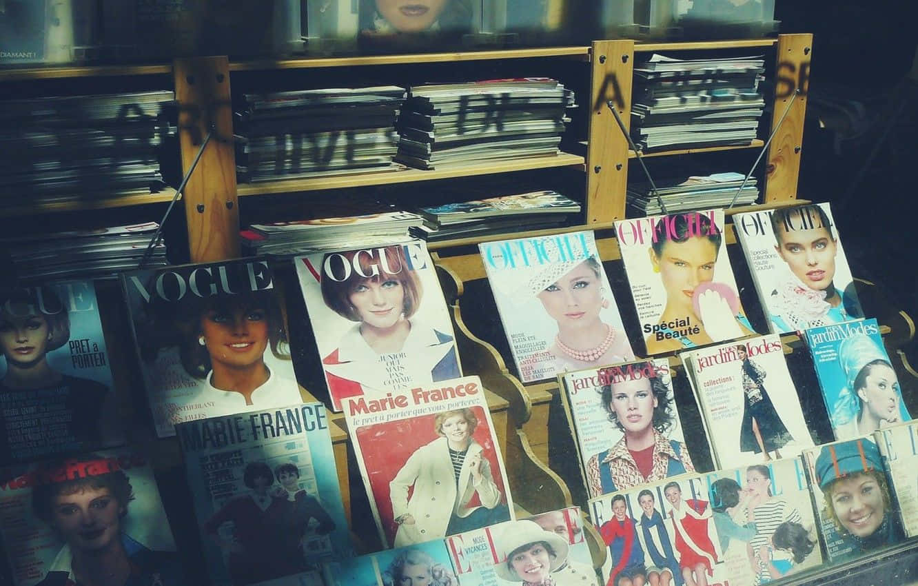 Magazine 桌布 壁紙 — 一個復古雜誌架展示經典Vogue和Marie France封面， featuring 1960年代和70年代的迷人時尚模特兒。