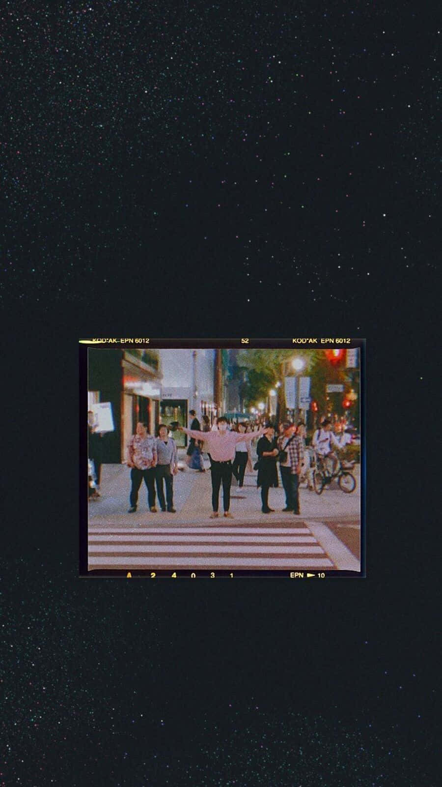Baddie Vintage 90's Aesthetic 桌布 壁紙 — 一個復古電影畫面顯示一群人在星空下的夜晚過馬路。