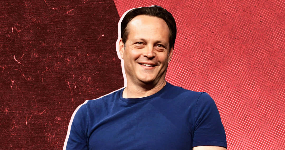 Vince Vaughn 桌布 壁紙 — 一個微笑嘅男人，身穿藍色T恤，企喺有圓點圖案嘅紋理紅色背景前面。