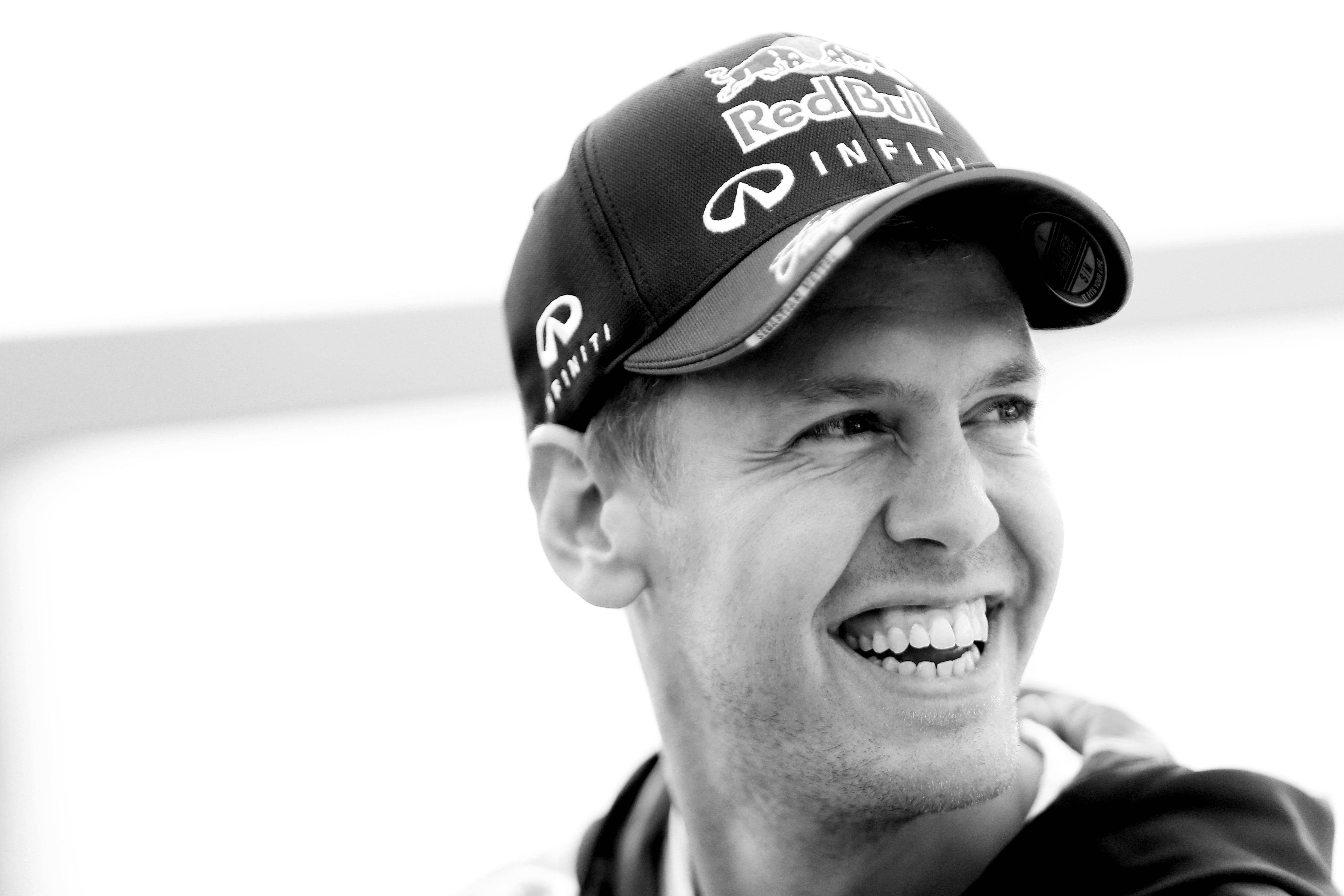 sebastian vettel 桌布 壁紙 — 一個微笑男士嘅黑白特寫，佢戴住有 Infiniti 標誌嘅 Red Bull 帽。