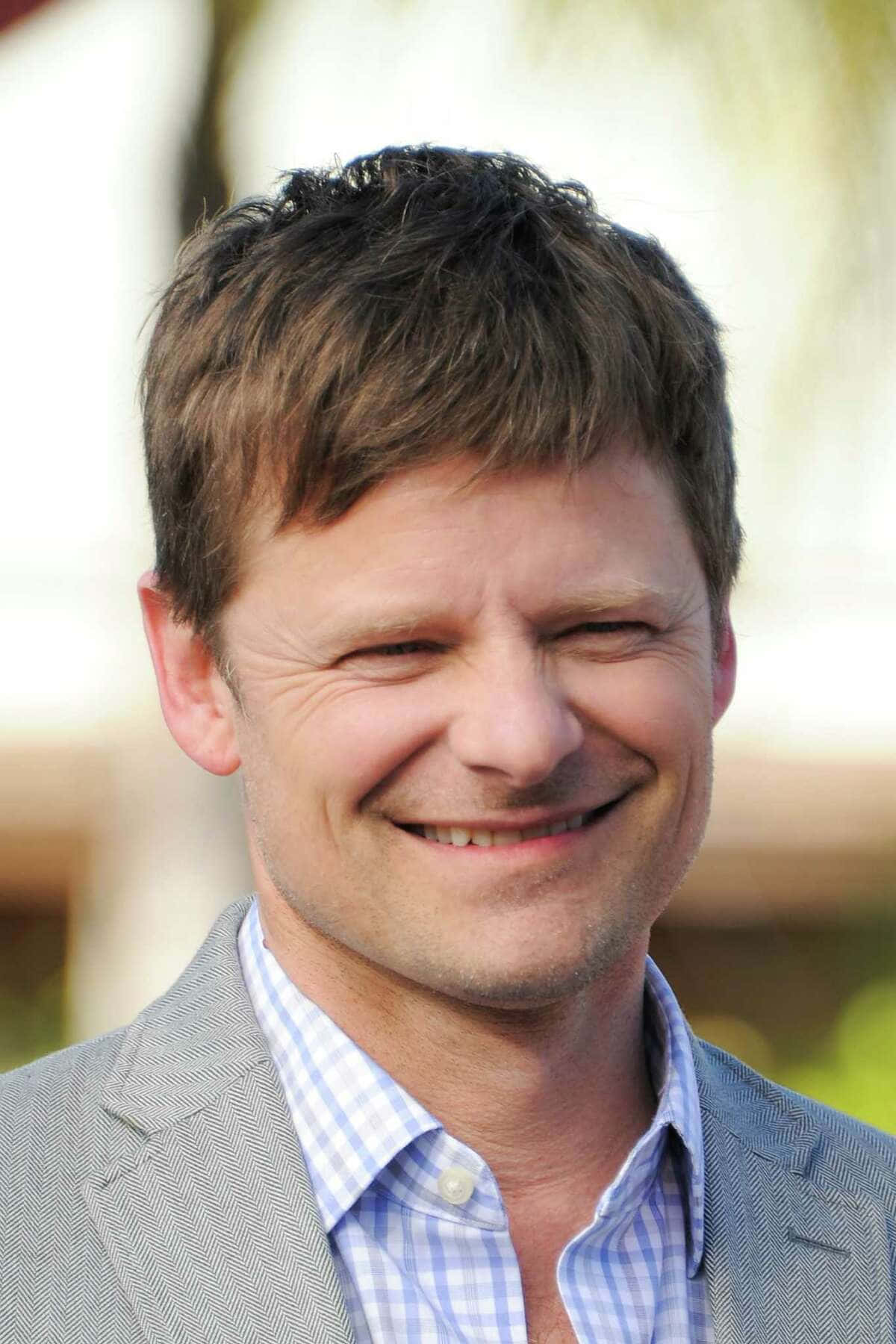 Steve Zahn 桌布 壁紙 — 一個微笑男子的特寫肖像，頭髮棕色凌亂，身穿灰色西裝和藍色格仔恤衫。