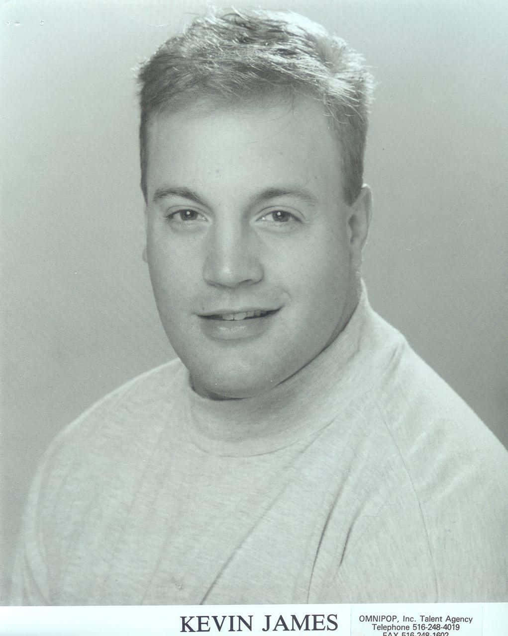 Kevin James 桌布 壁紙 — 一個微笑男子穿著高領毛衣在純色背景前的黑白工作室肖像。