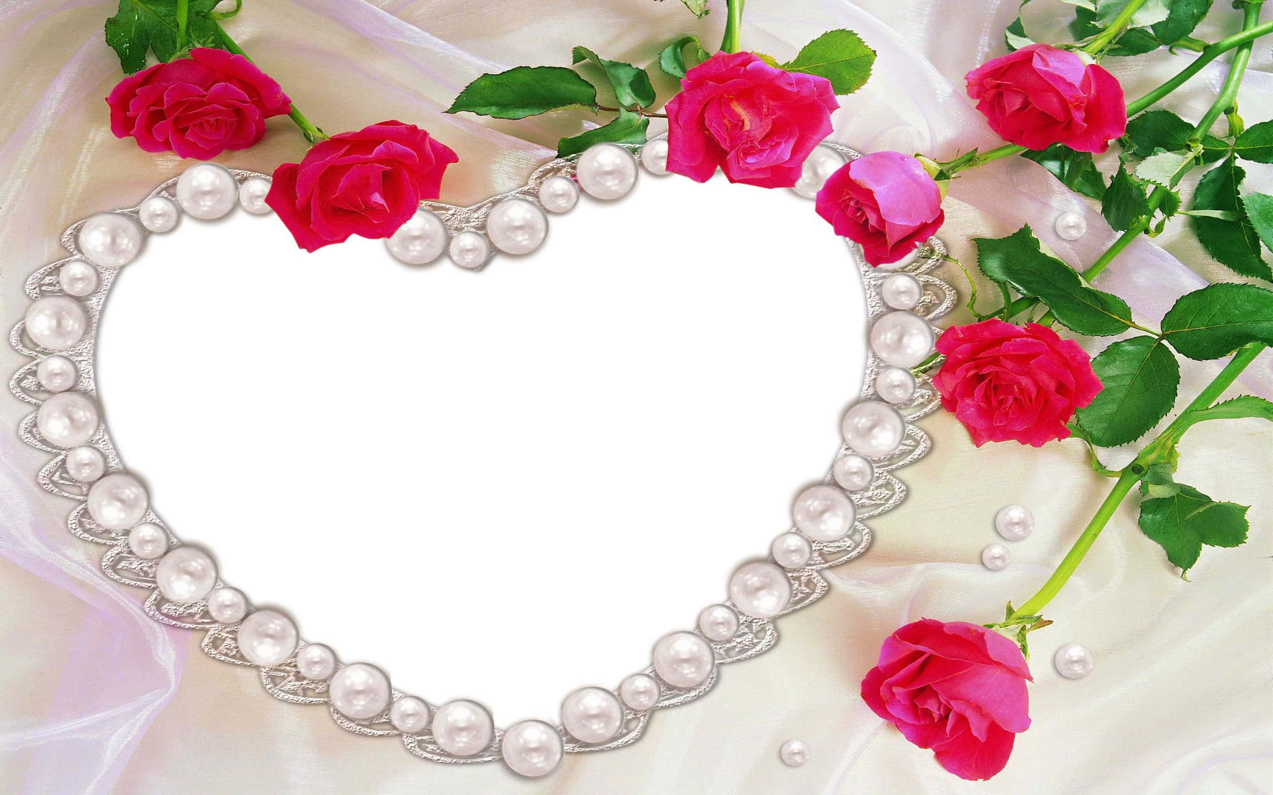 Rose Heart 桌布 壁紙 — 一個心形珍珠相框，飾有鮮豔的粉紅玫瑰和綠葉，放置在柔軟的奶油色布料上。