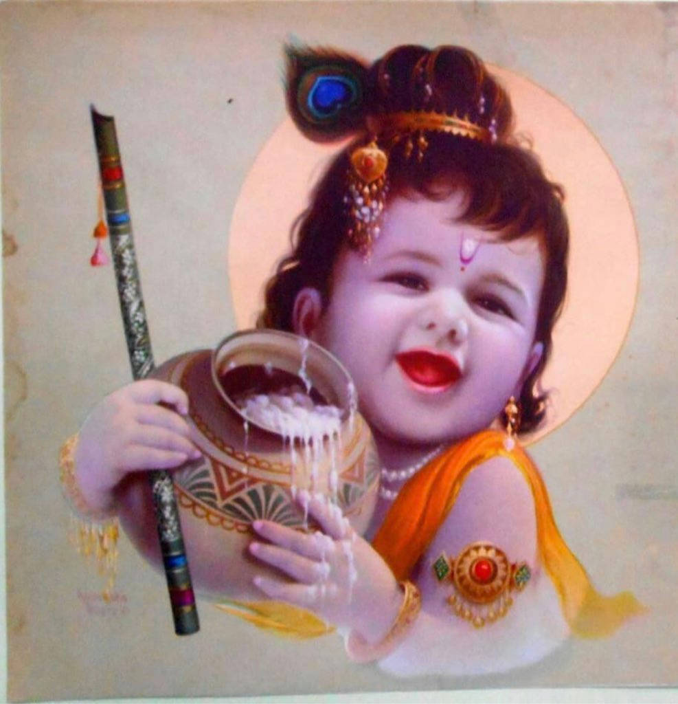 神 桌布 壁紙 — 一個快樂的嬰兒克里希納戴著孔雀羽毛皇冠，拿著一個溢出的壺和笛子，背景是柔和的光環。