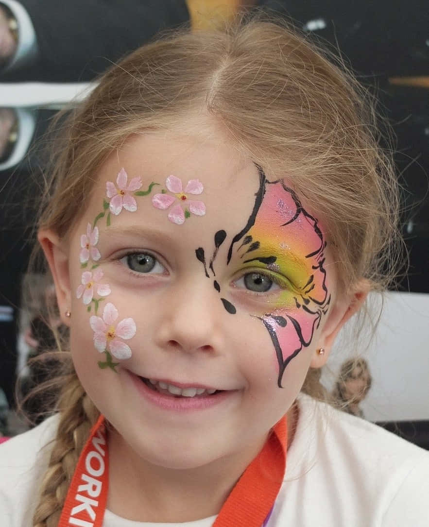 Butterfly Face Painting 桌布 壁紙 — 一個快樂的小女孩，半邊臉畫上粉紅色的櫻花和鮮豔的蝴蝶圖案。