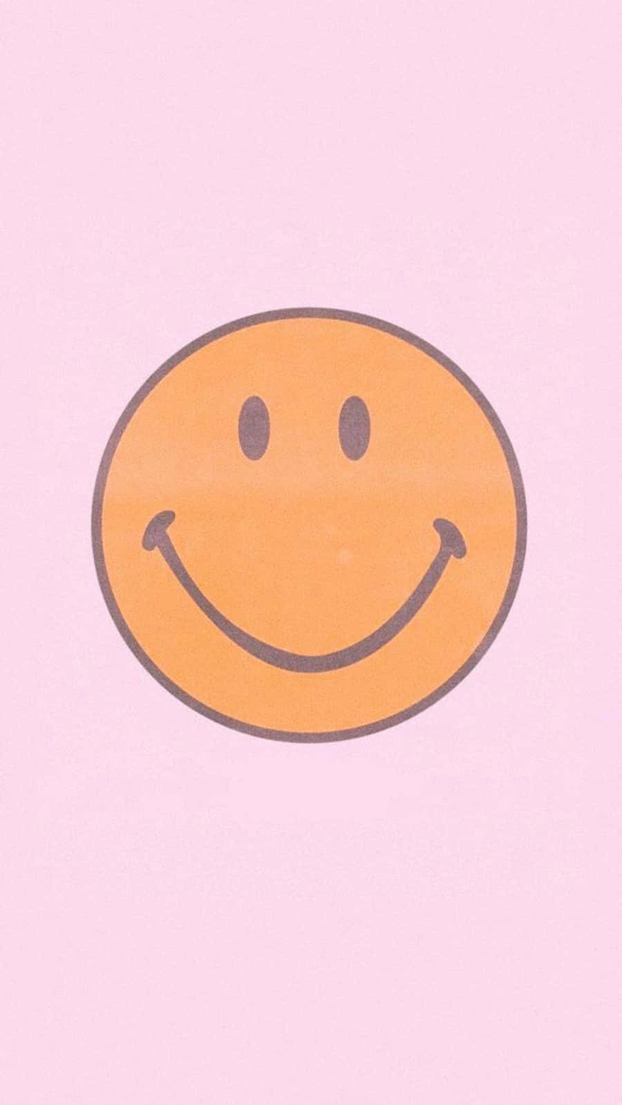 Smiley 桌布 壁紙 — 一個快樂的橙色笑臉，帶有簡單的黑色特徵，居中在柔和的粉紅色背景上。