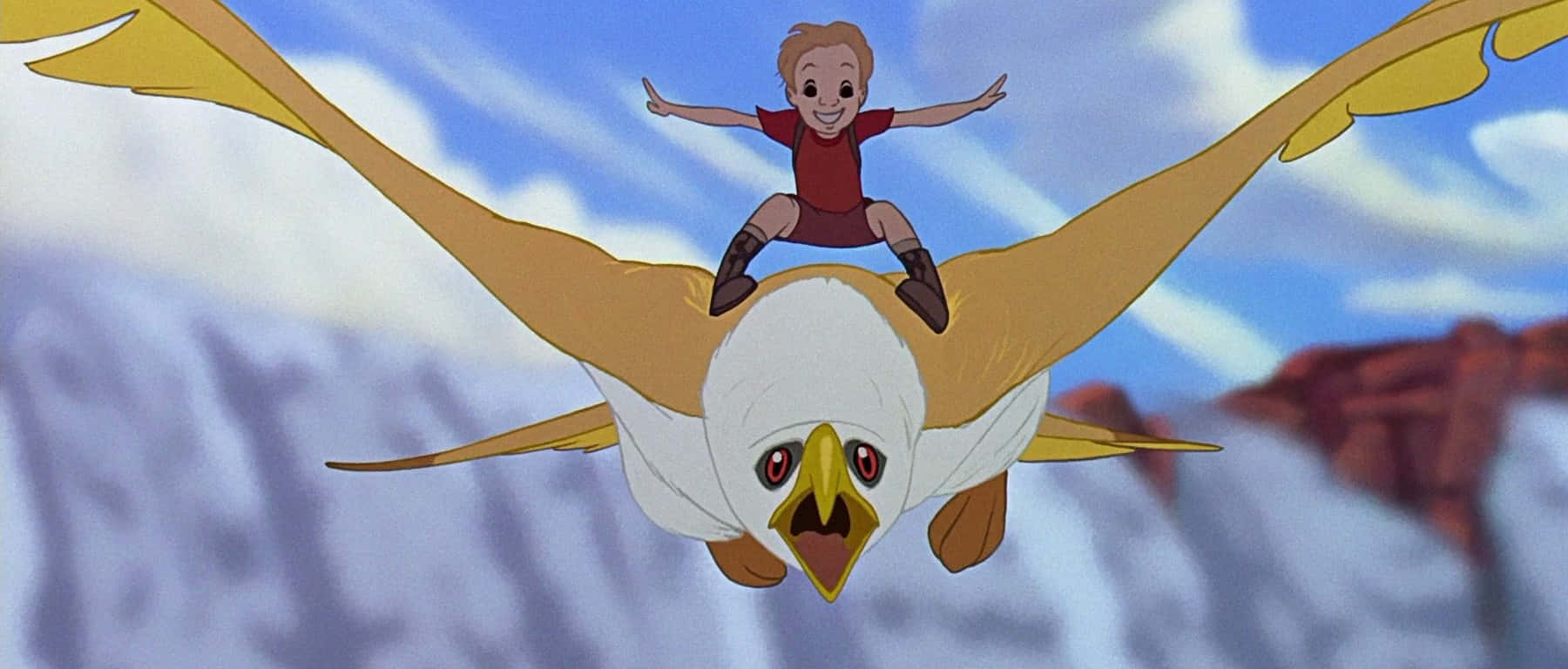 The Rescuers Down Under 桌布 壁紙 — 一個快樂的男孩騎著一隻巨大的白色和黃色老鷹，在岩石地形上空，穿過有蓬鬆雲朵的藍天翱翔。