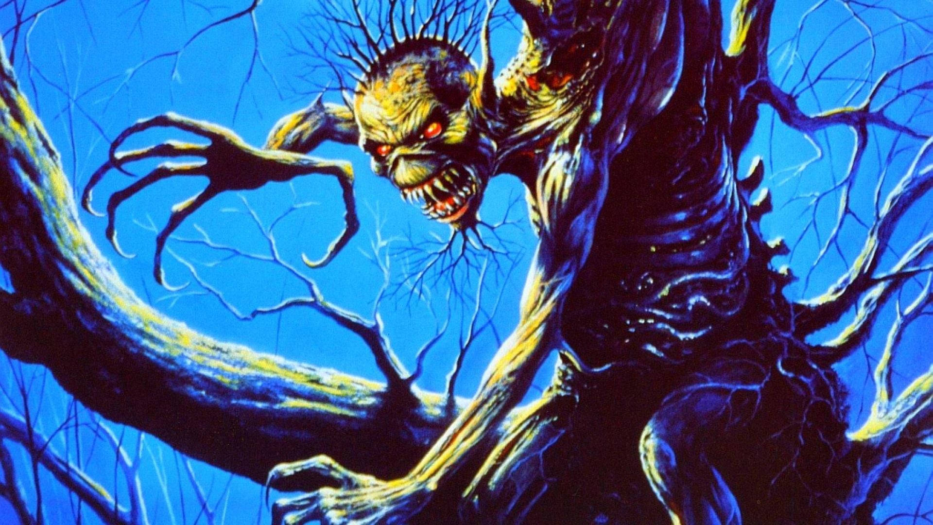 Iron Maiden - Fear of the Dark 壁紙 — 一個怪誕的惡魔實體，有著發光的紅色眼睛和尖刺頭髮，從扭曲的樹枝中出現，背景是鮮豔的藍天。