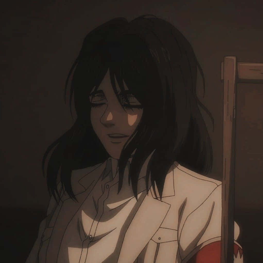 Pieck Finger 桌布 壁紙 — 一個憂鬱的動漫女孩，深色頭髮，穿著白色襯衫，坐在昏暗的燈光下，她的臉被柔和的光芒照亮。