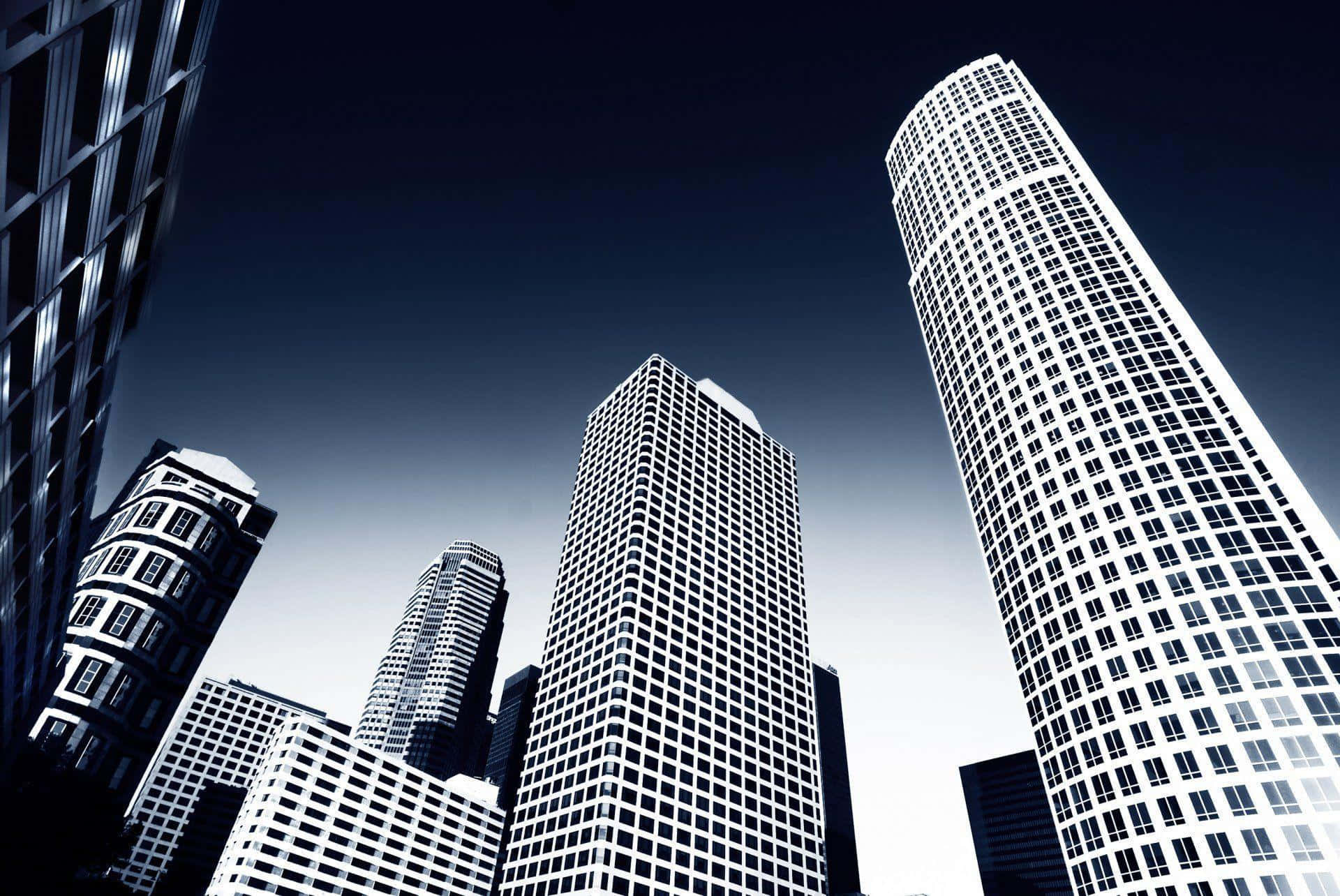Buildings 桌布 壁紙 — 一個戲劇性的低角度視角，高聳的摩天大樓刺穿深藍色的暮色天空。